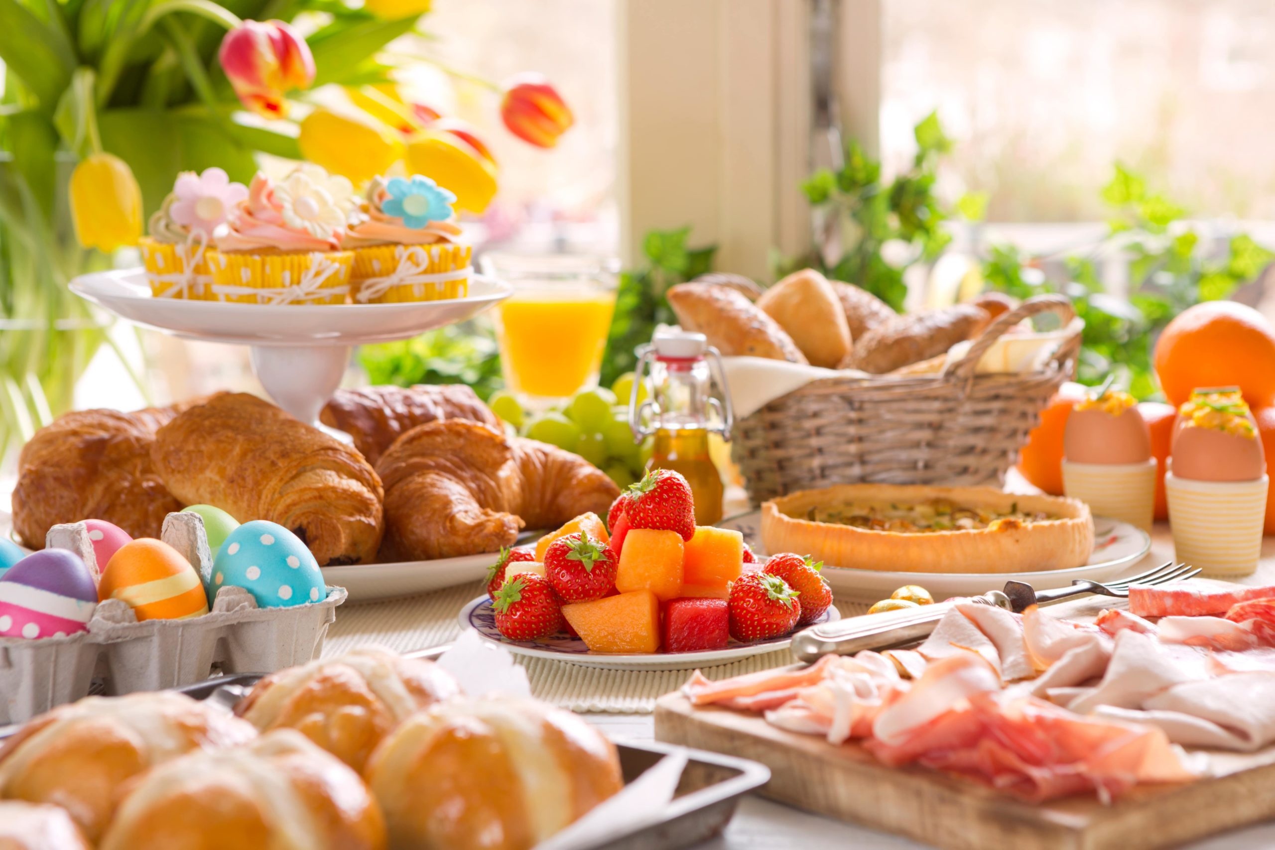 Easter breakfast with pastries, fruits, and eggs HD Wallpaper