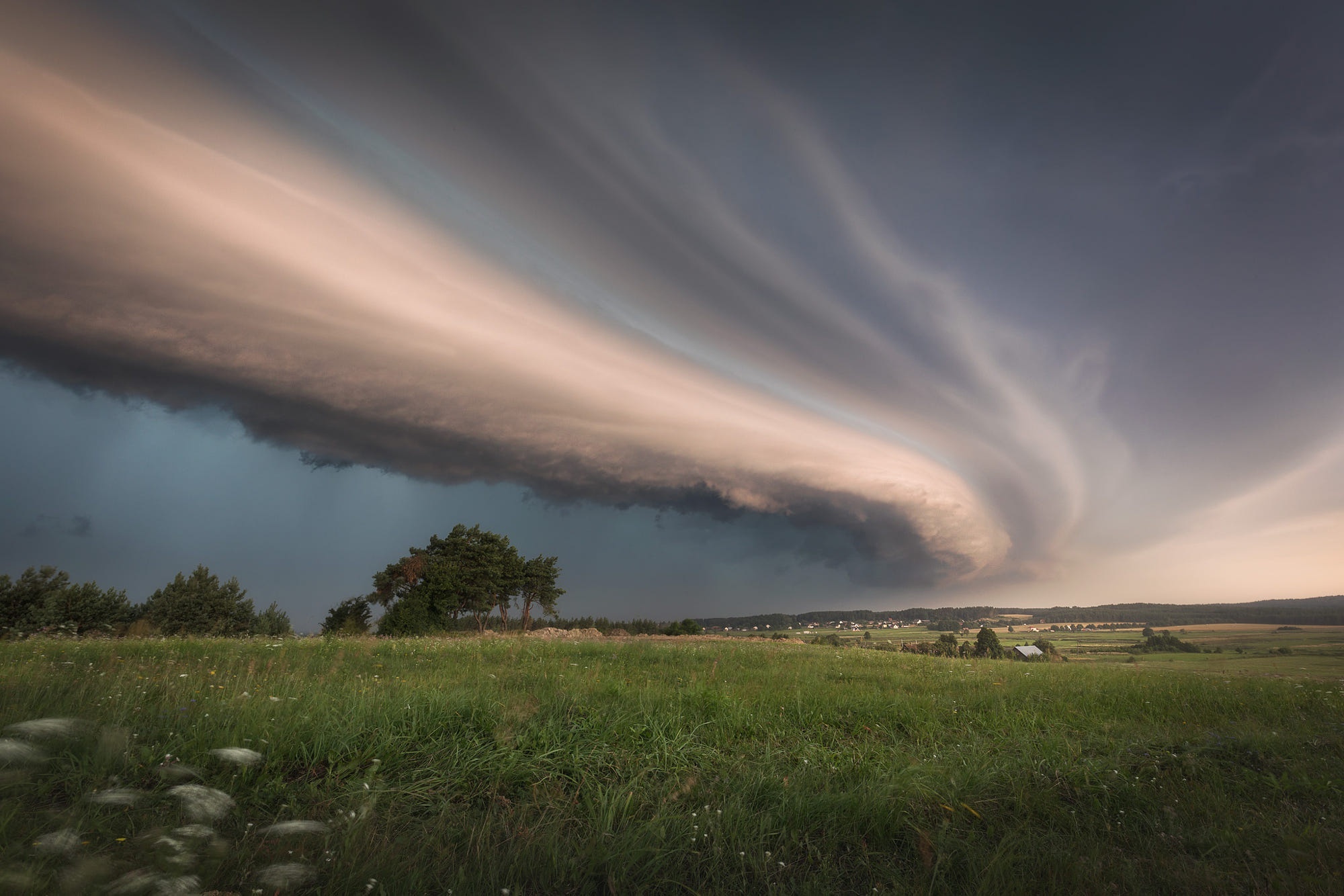 Dramatic storm clouds over a grassy field HD Wallpaper