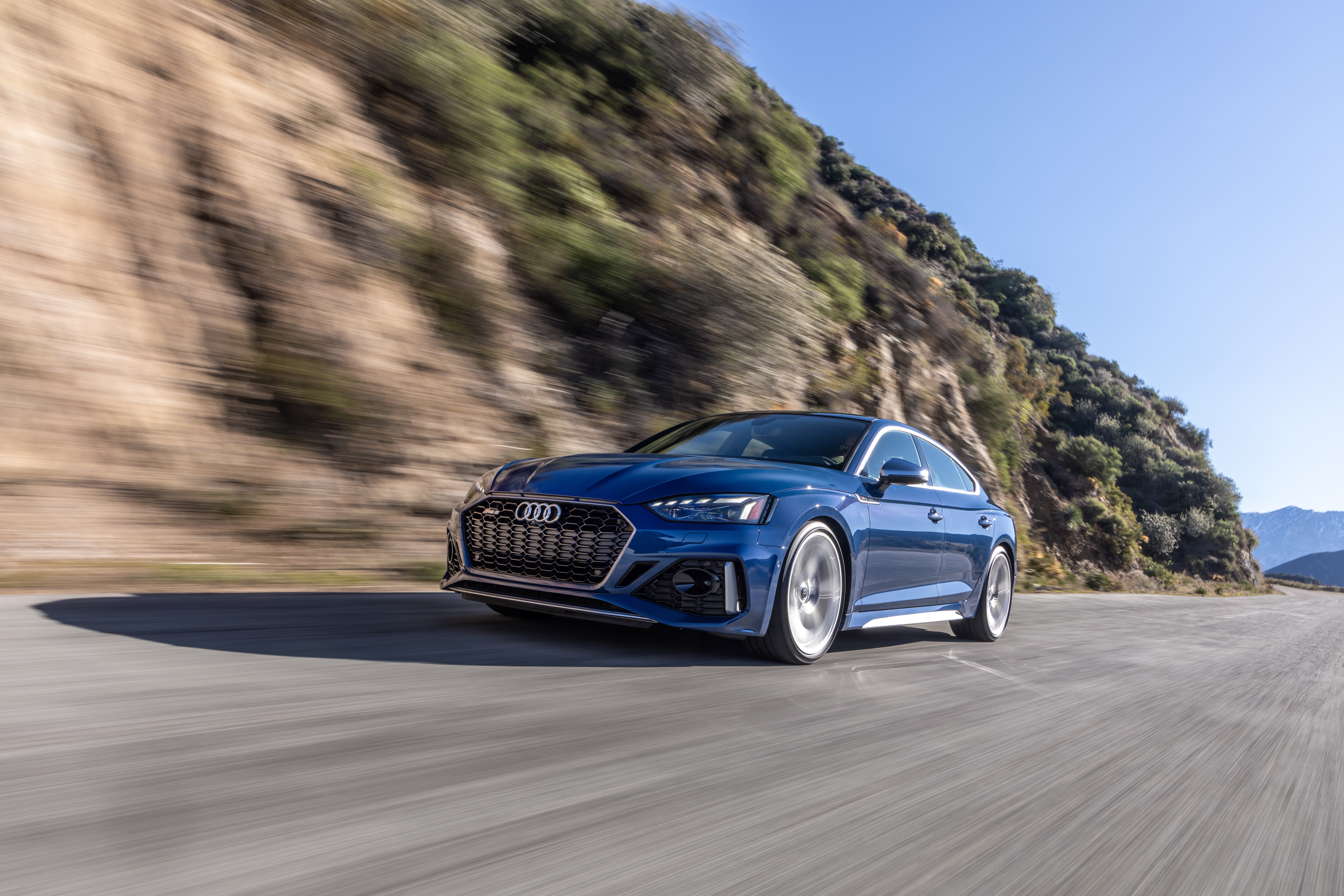 Blue Audi RS5 driving on a mountain road HD Wallpaper