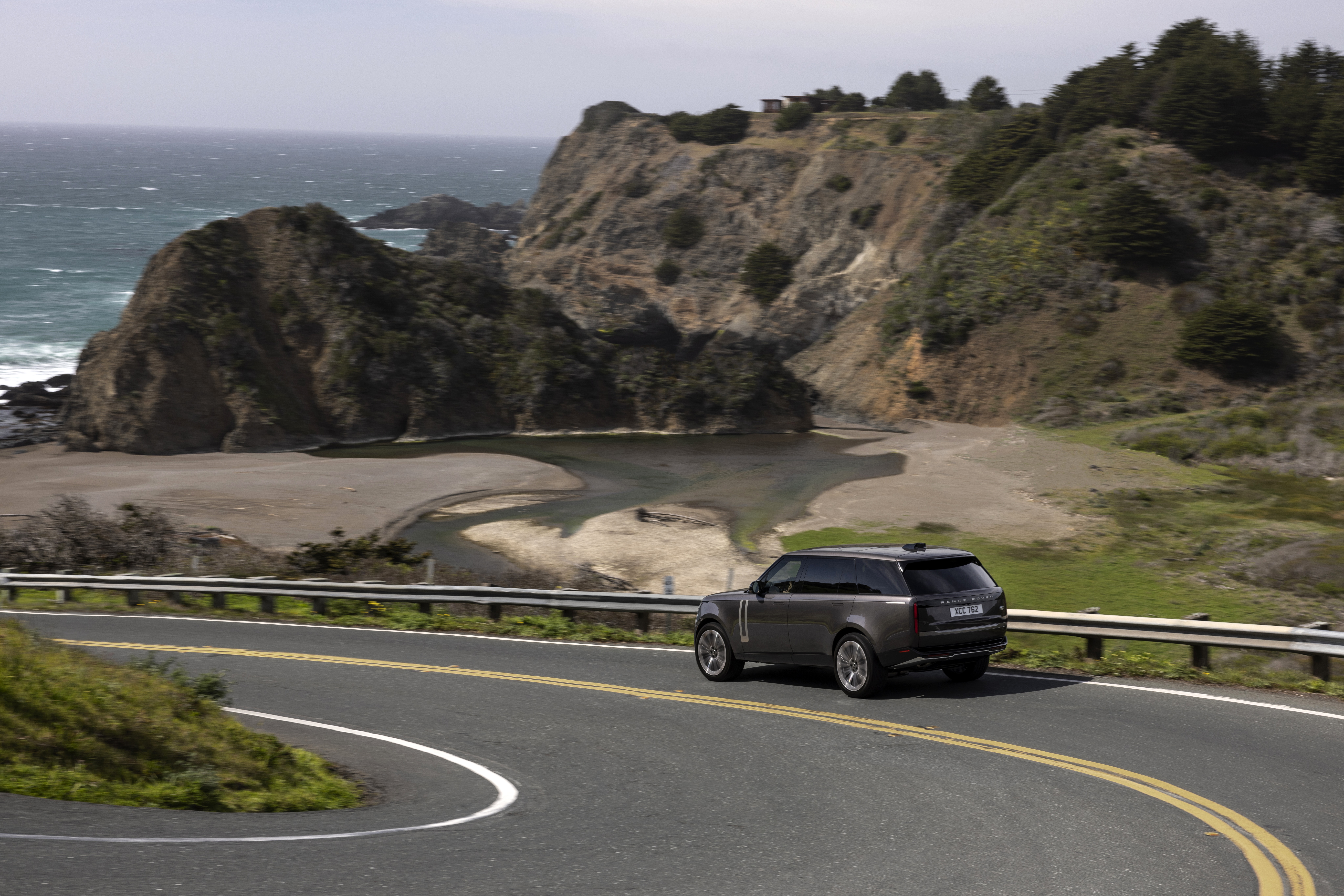 Range Rover SE P400 driving on coastal road HD Wallpaper