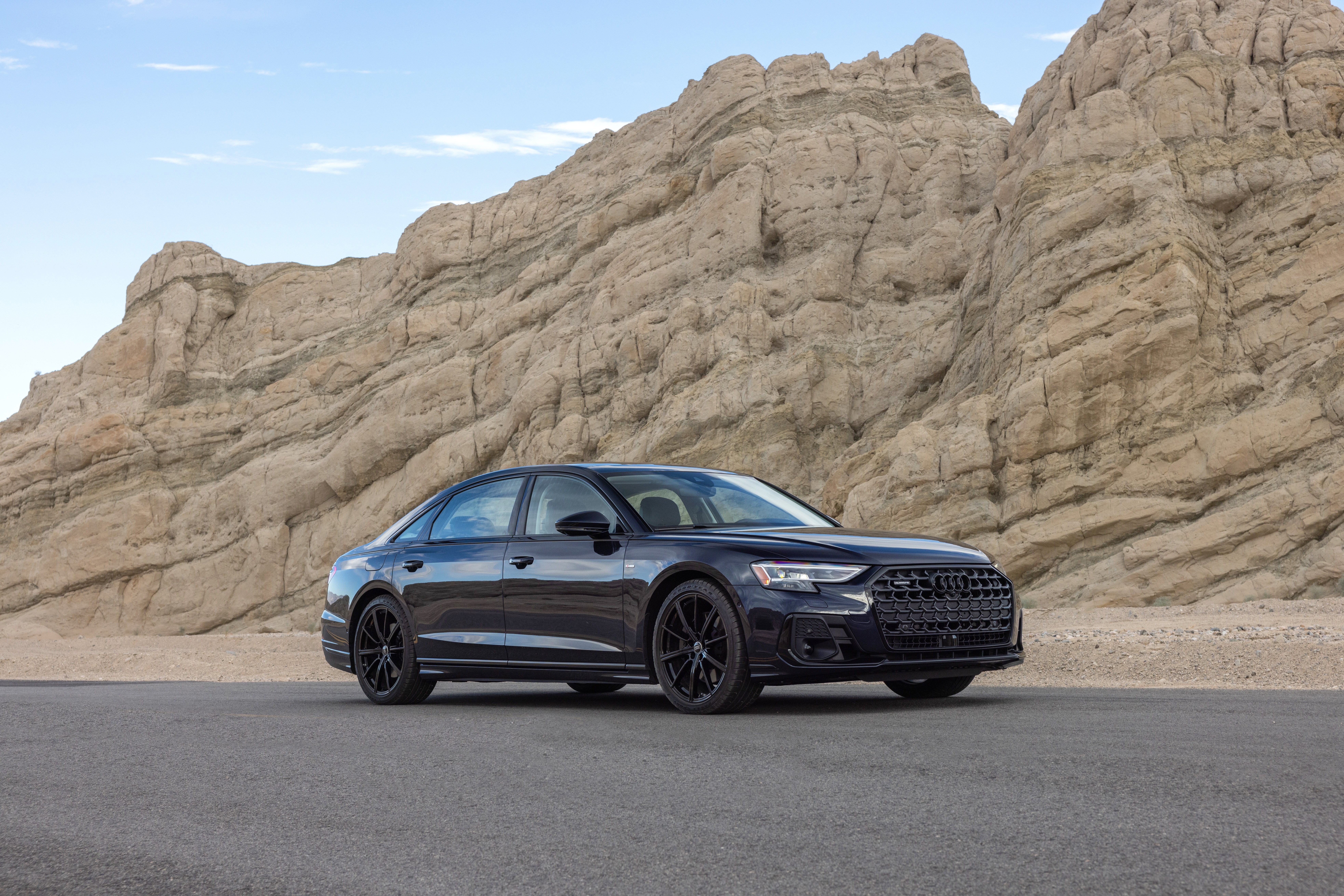 Audi A8 sedan parked on a road with rocky mountains HD Wallpaper