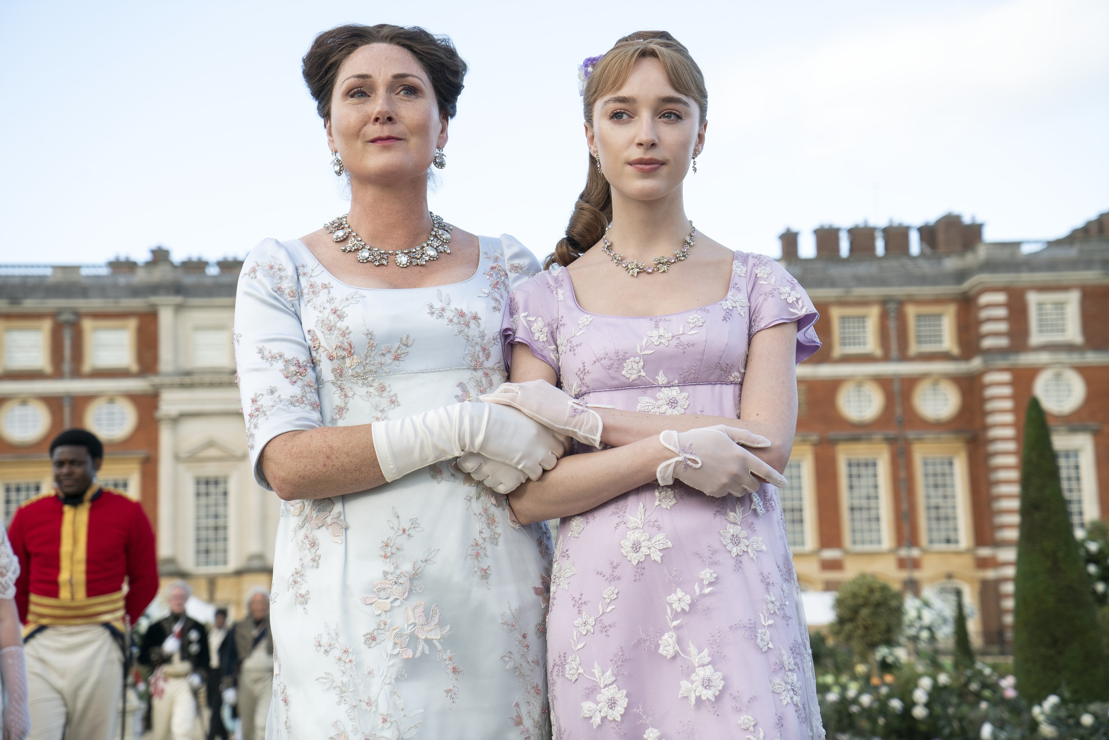 Two women in Regency-era dresses in front of a building HD Wallpaper