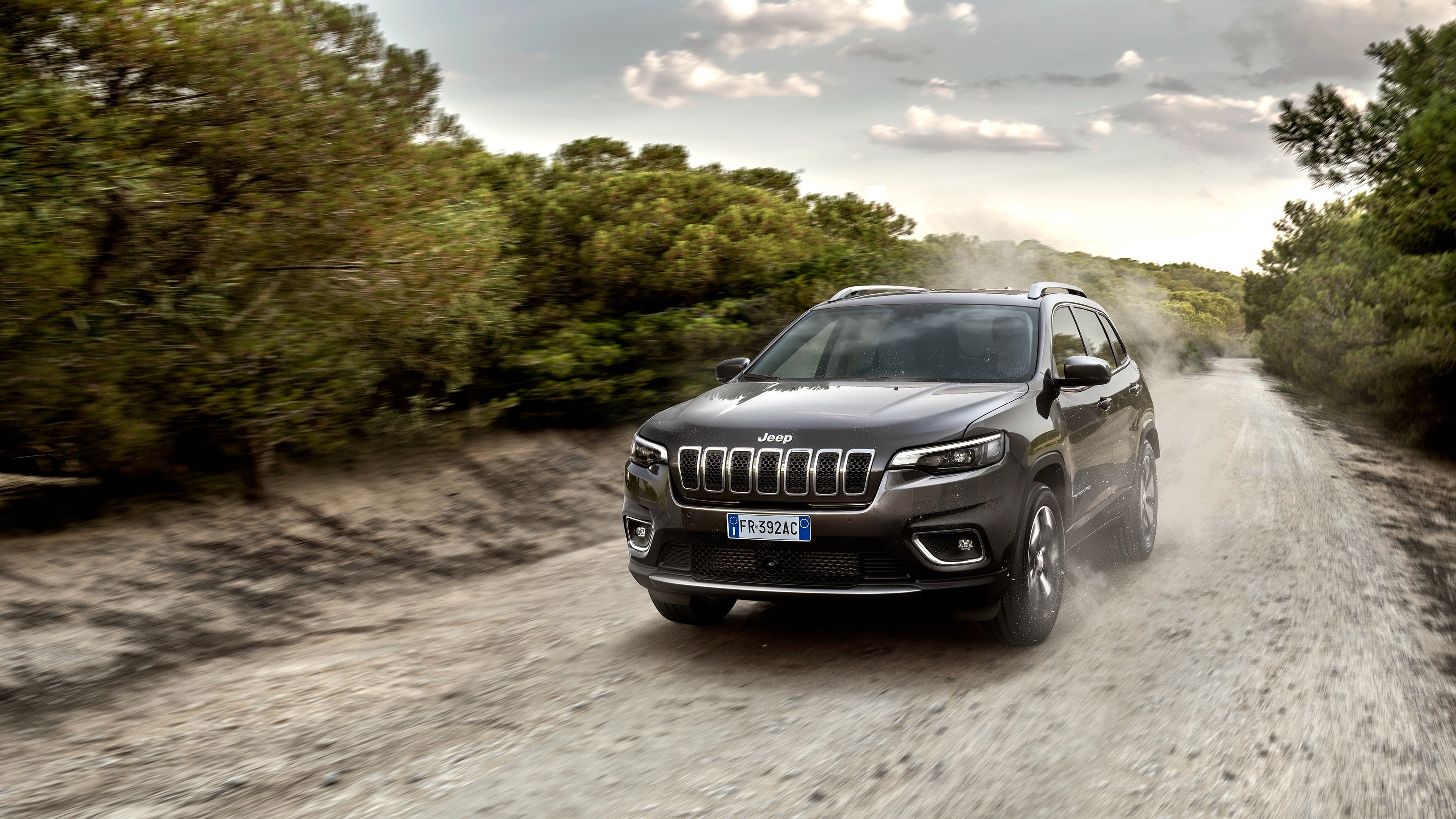 Jeep Cherokee driving on a dirt road HD Wallpaper