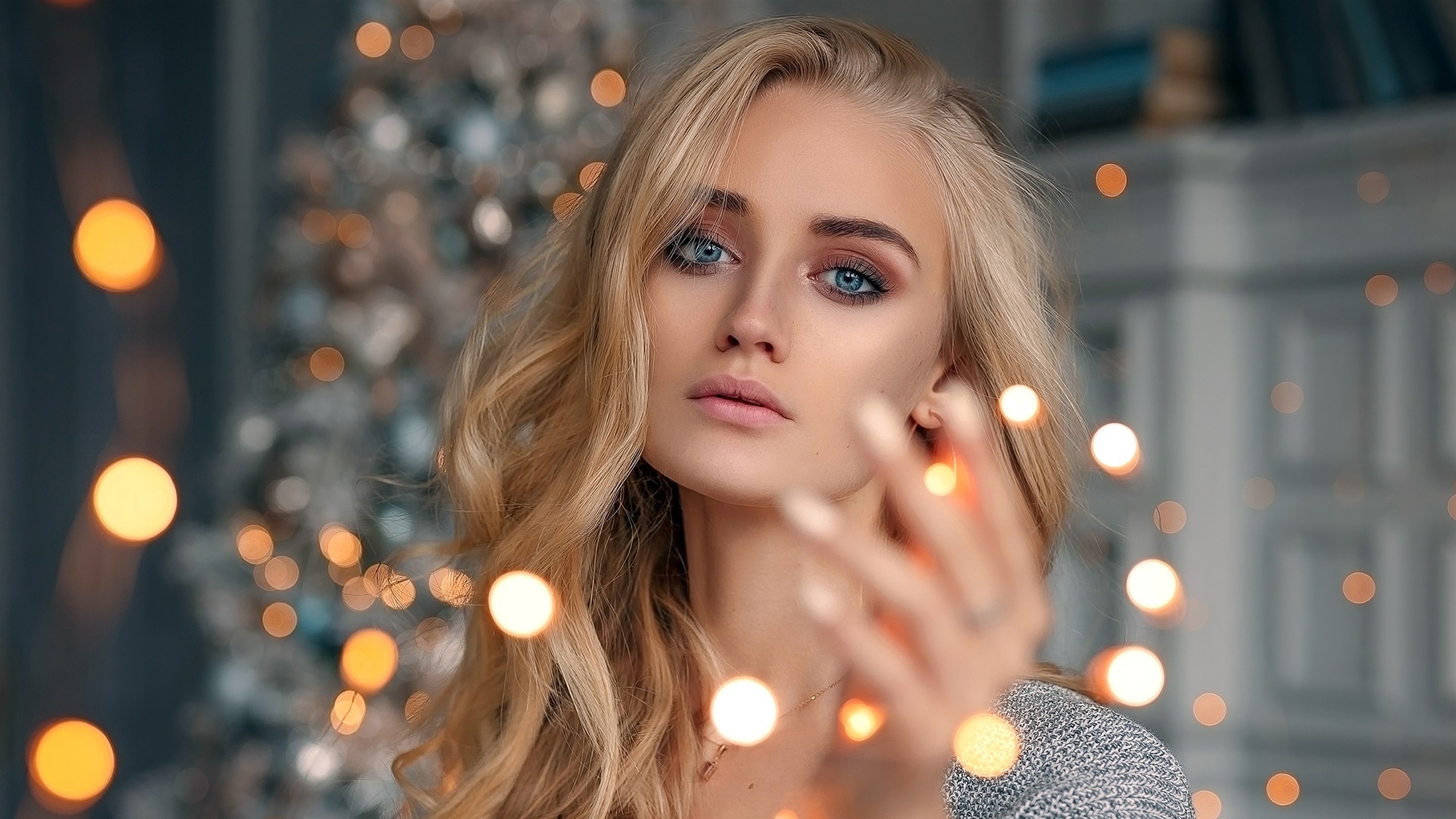 Woman with blonde hair and blue eyes near Christmas lights HD Wallpaper