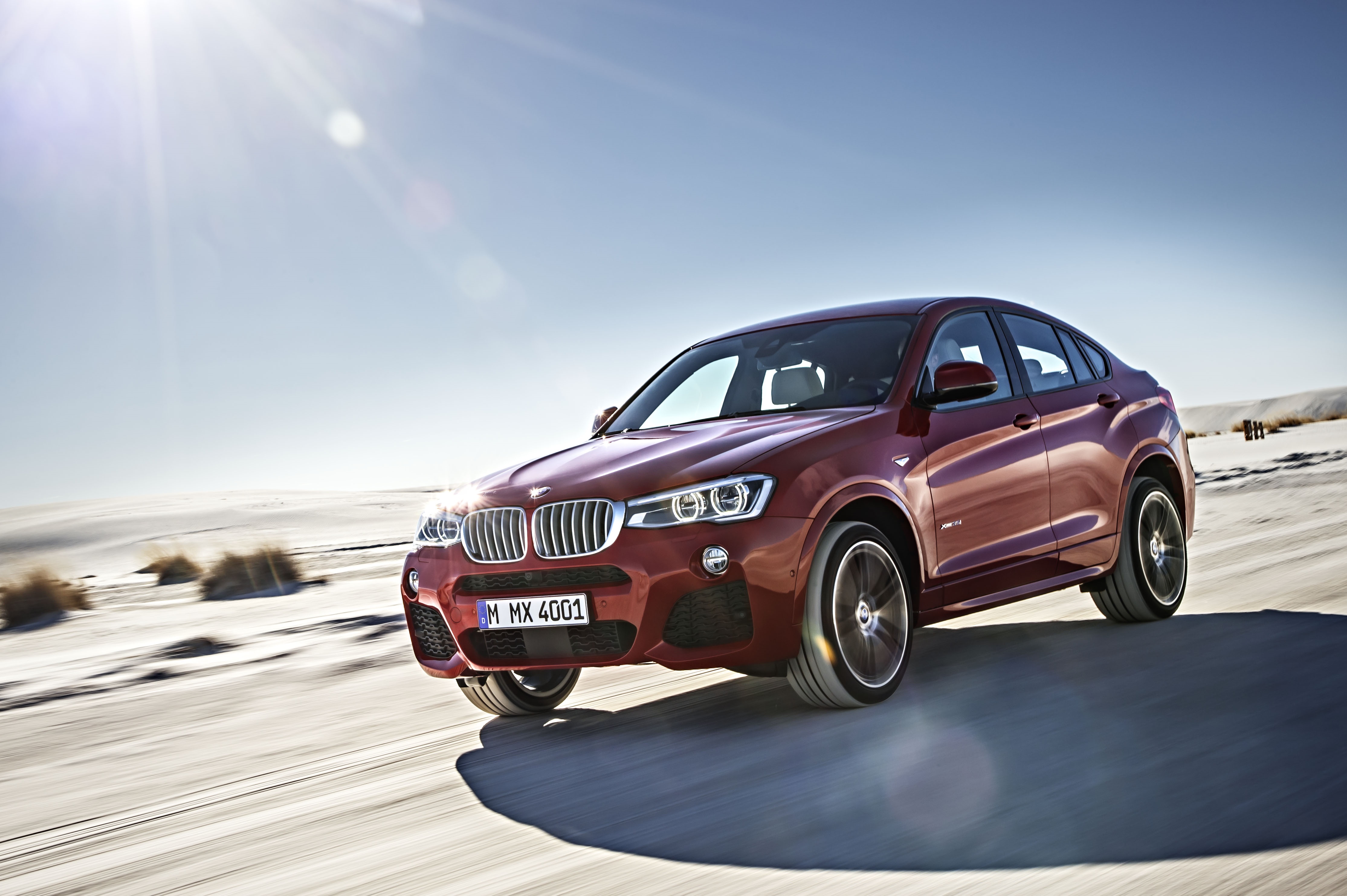 Red BMW X4 xDrive35i driving on a sandy road HD Wallpaper