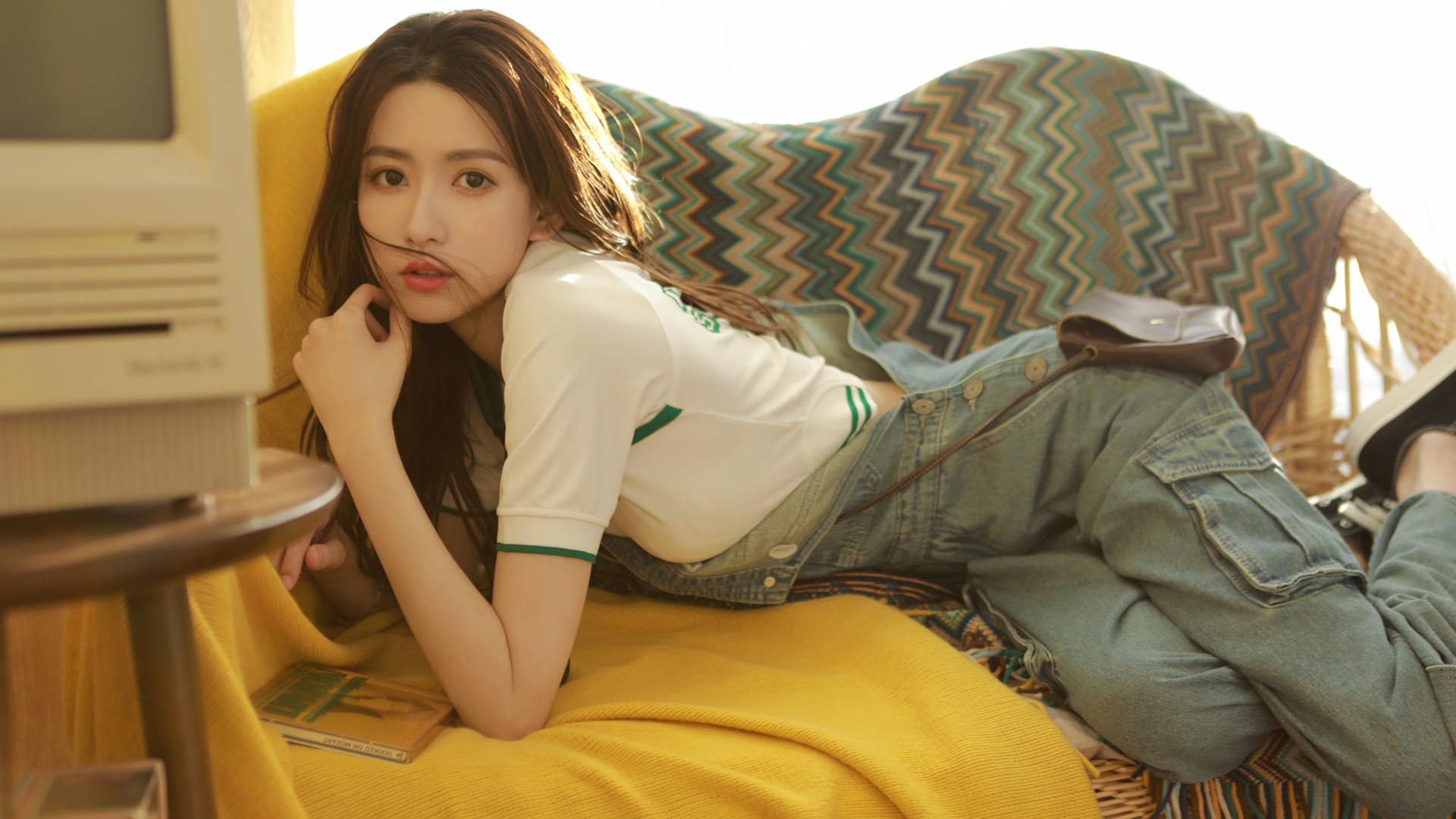 Asian woman in casual clothes lounging on a couch HD Wallpaper