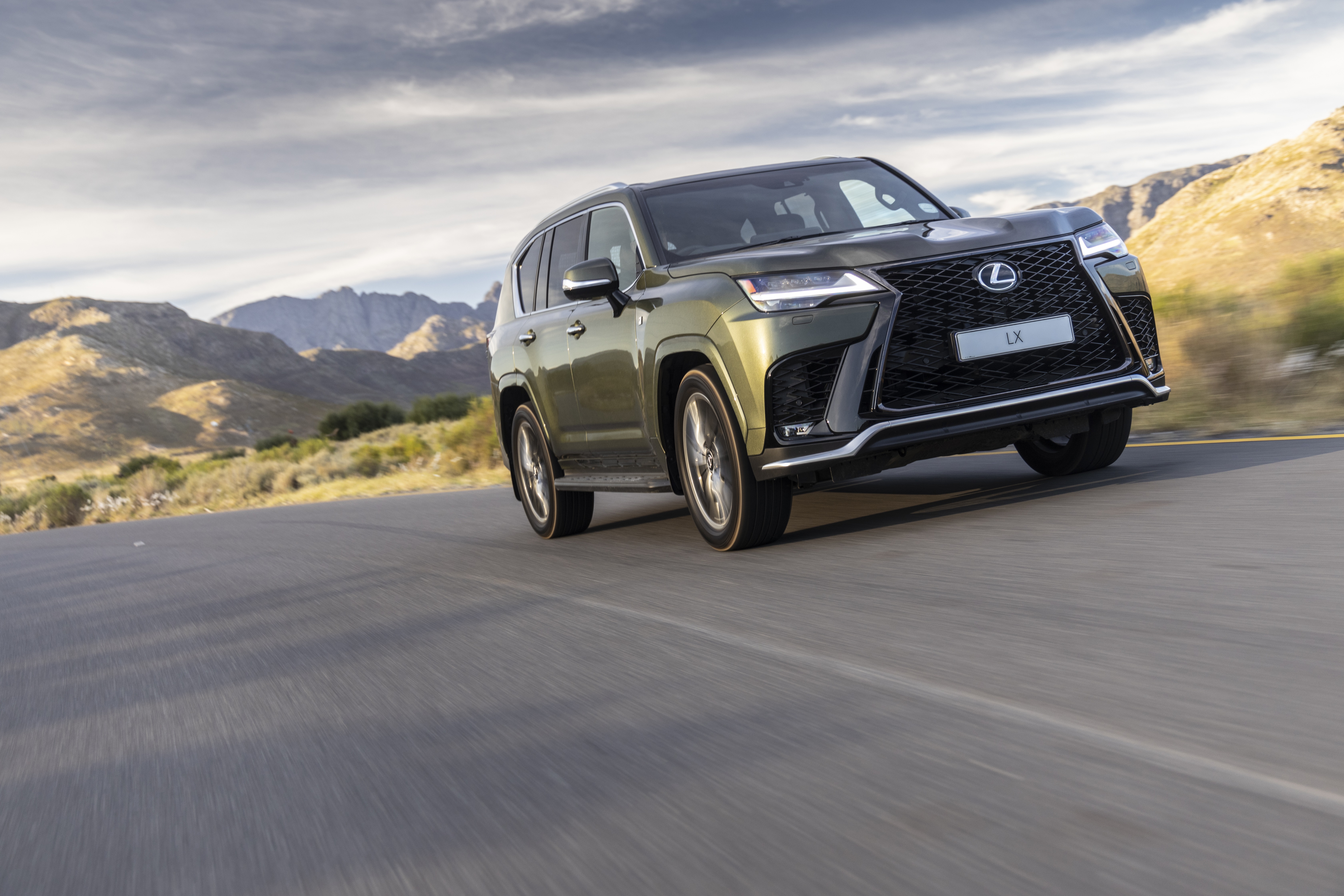 Lexus LX 600 driving on a road with mountains HD Wallpaper