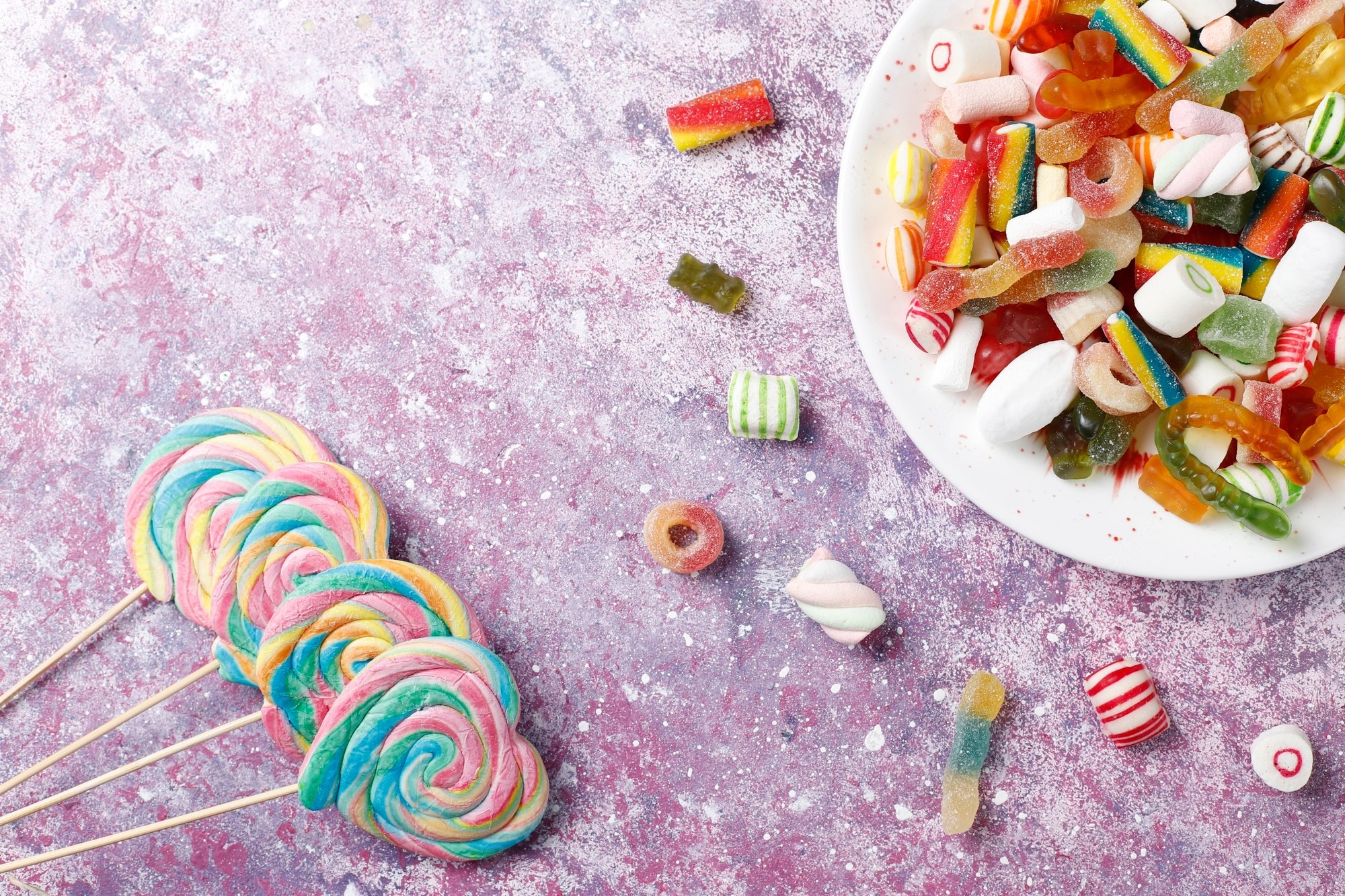 Colorful lollipops and candies on a textured surface HD Wallpaper