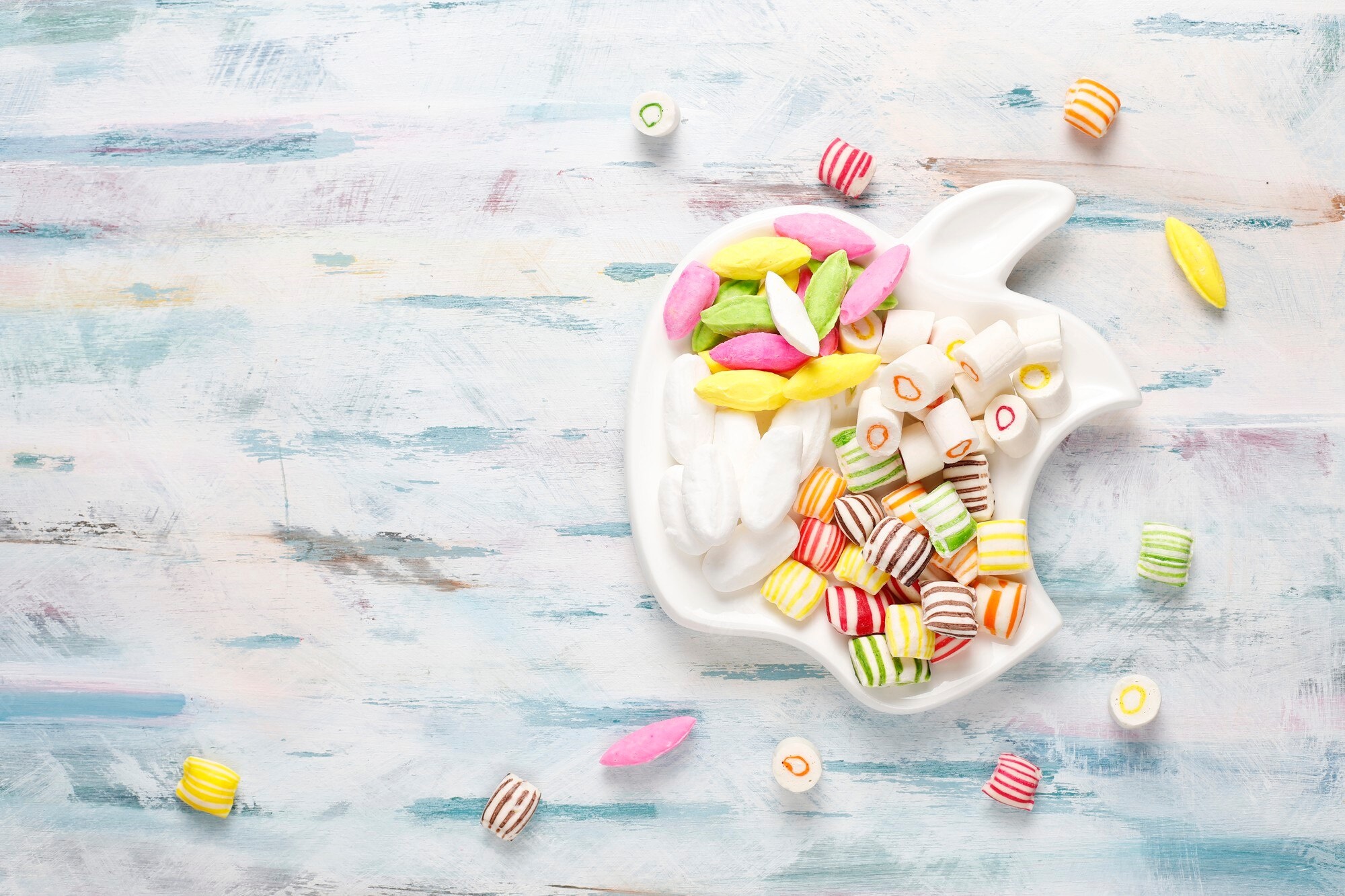 Assortment of colorful candies on a white apple-shaped plate HD Wallpaper