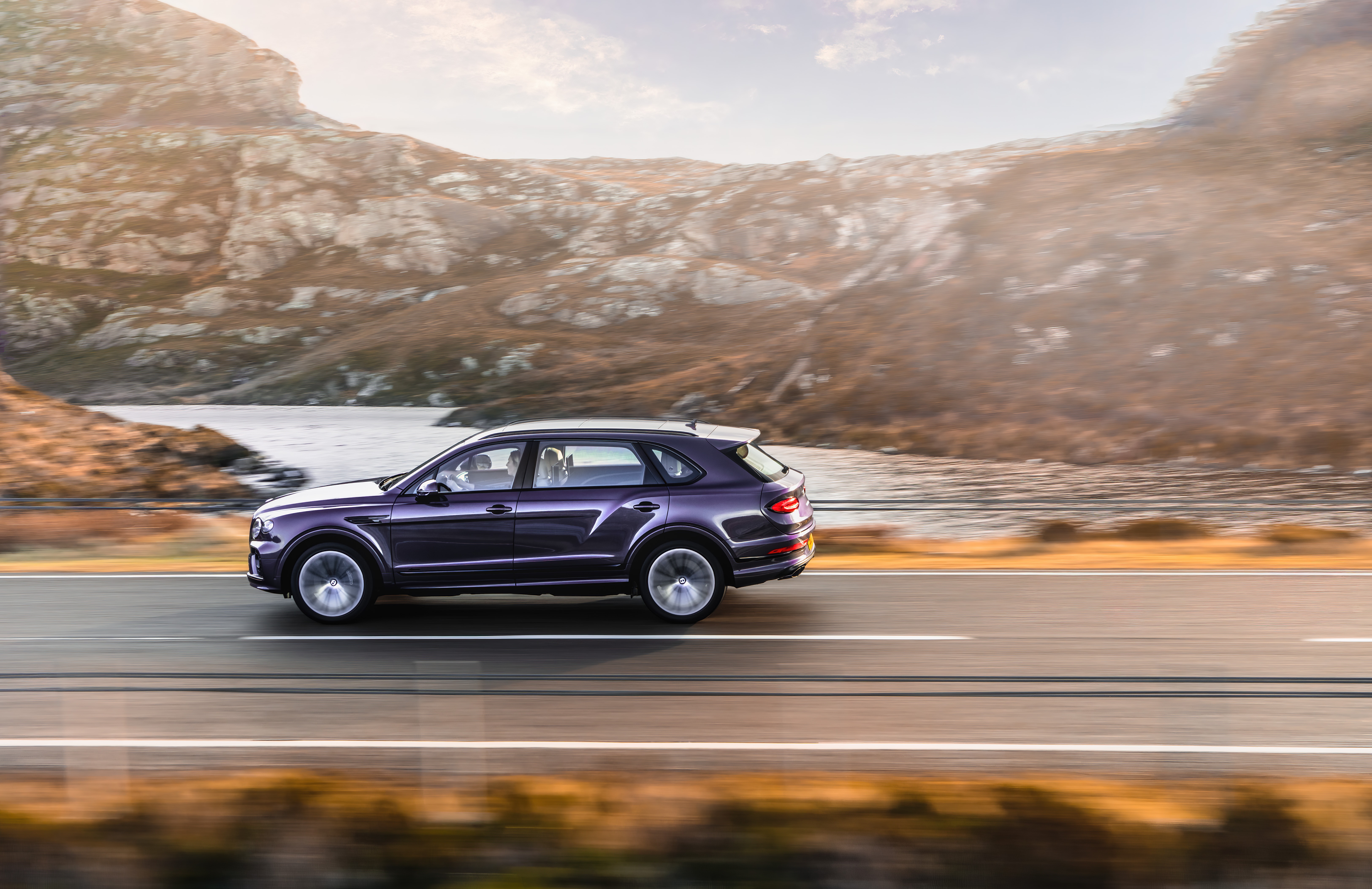 Bentley Bentayga EWB driving on a road with mountains HD Wallpaper