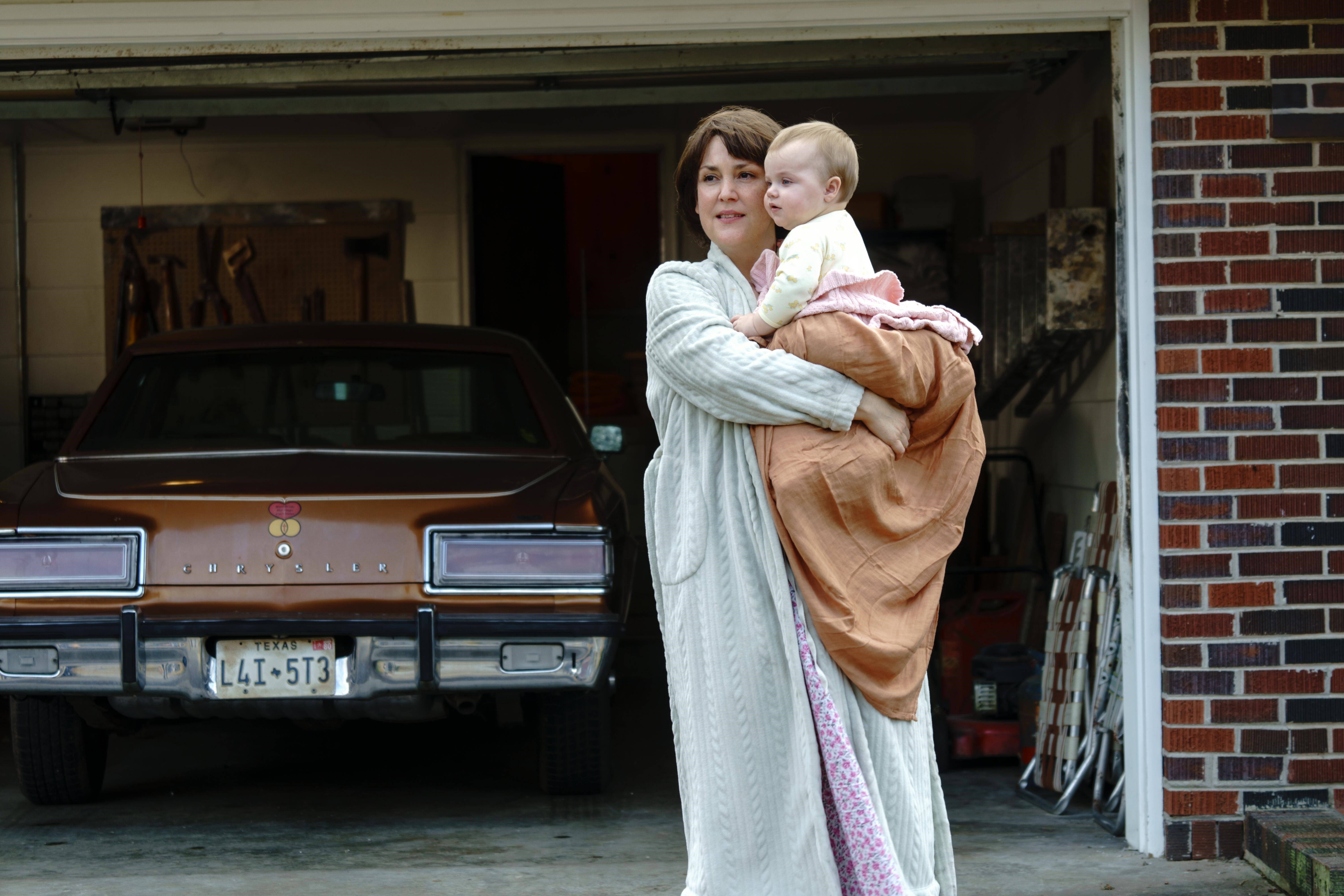 Melanie Lynskey holding a baby in front of a car HD Wallpaper