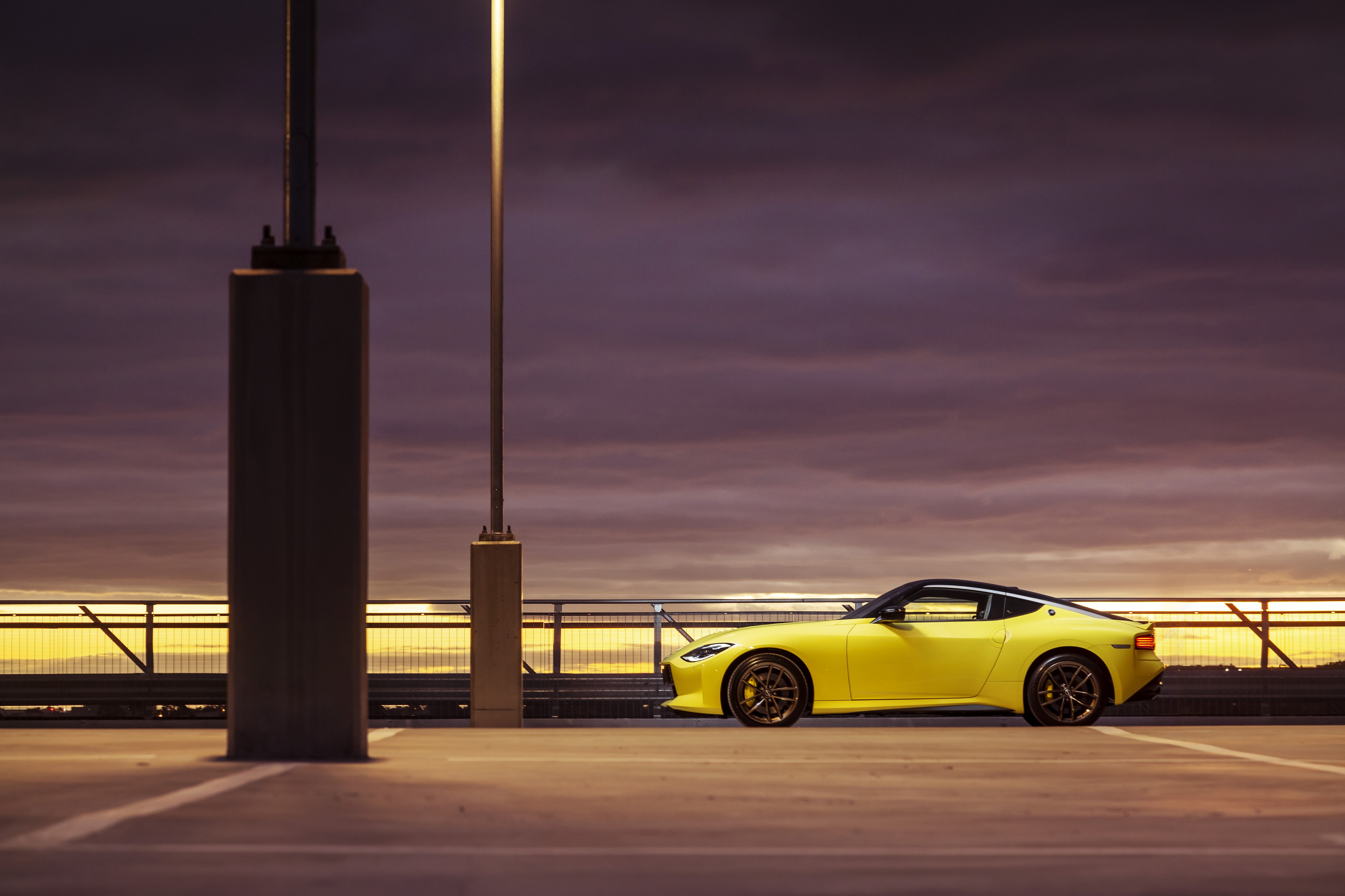 Yellow Nissan Z parked on a rooftop at dusk HD Wallpaper