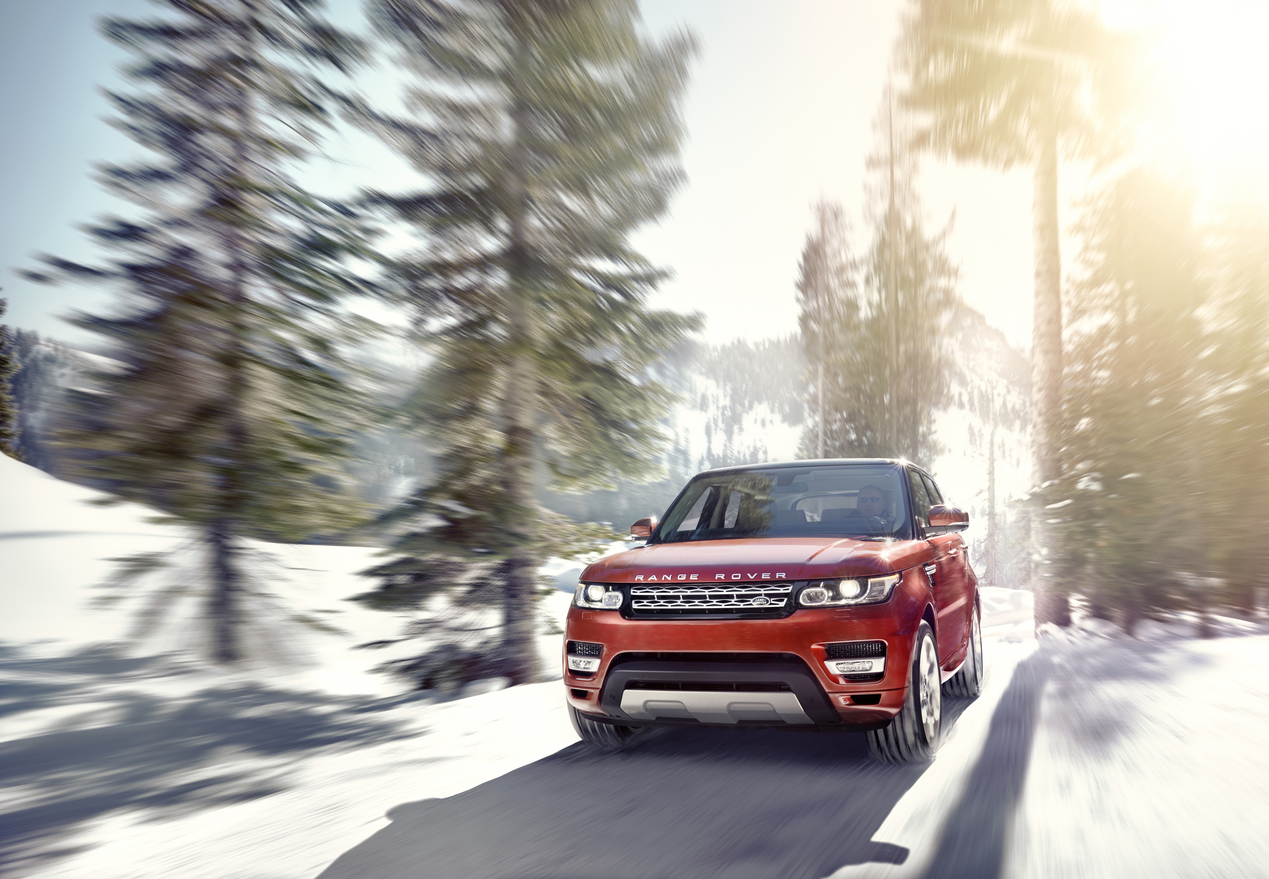 Orange Range Rover Sport driving on a snowy road HD Wallpaper