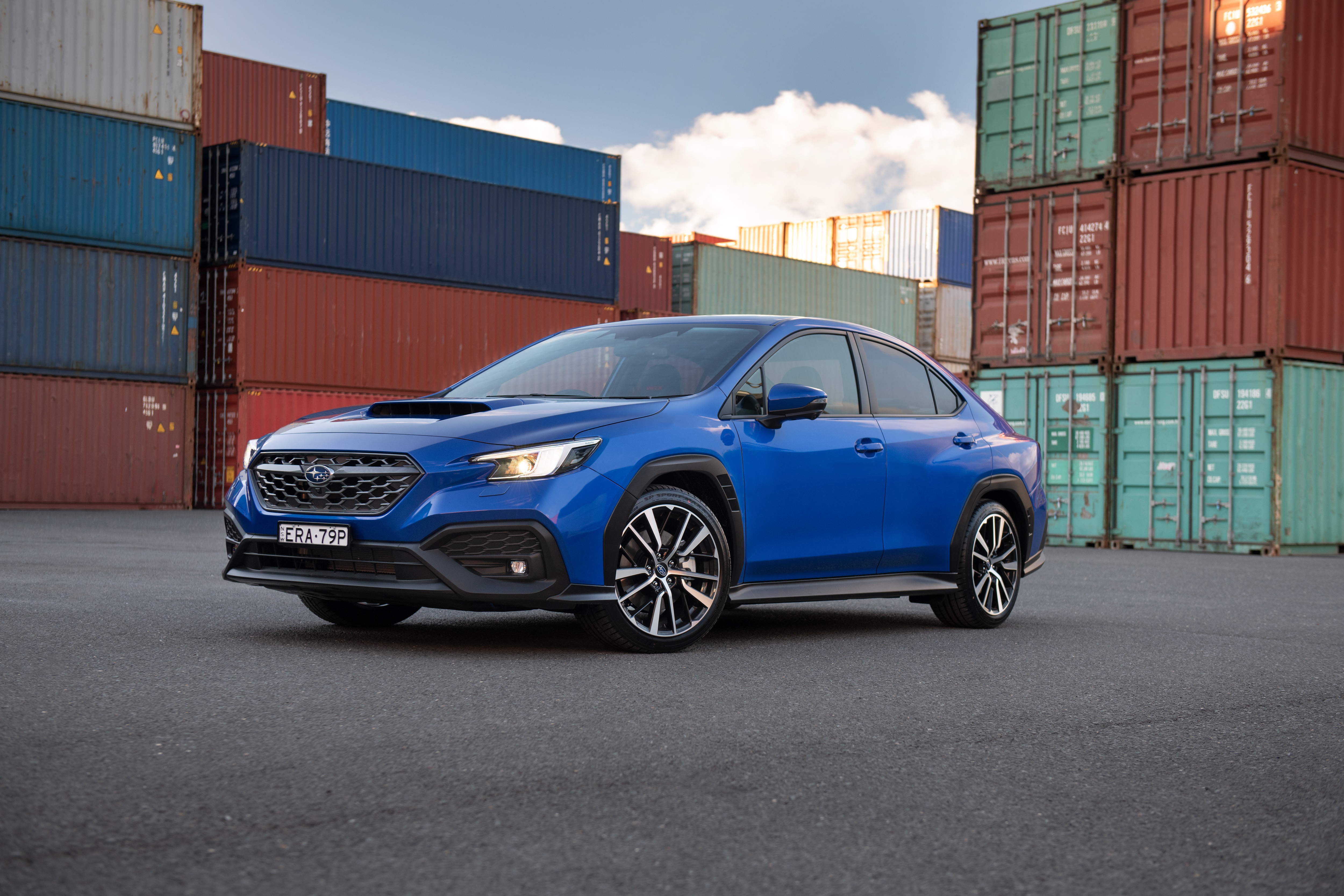 Blue Subaru WRX Sportswagon parked near shipping containers HD Wallpaper