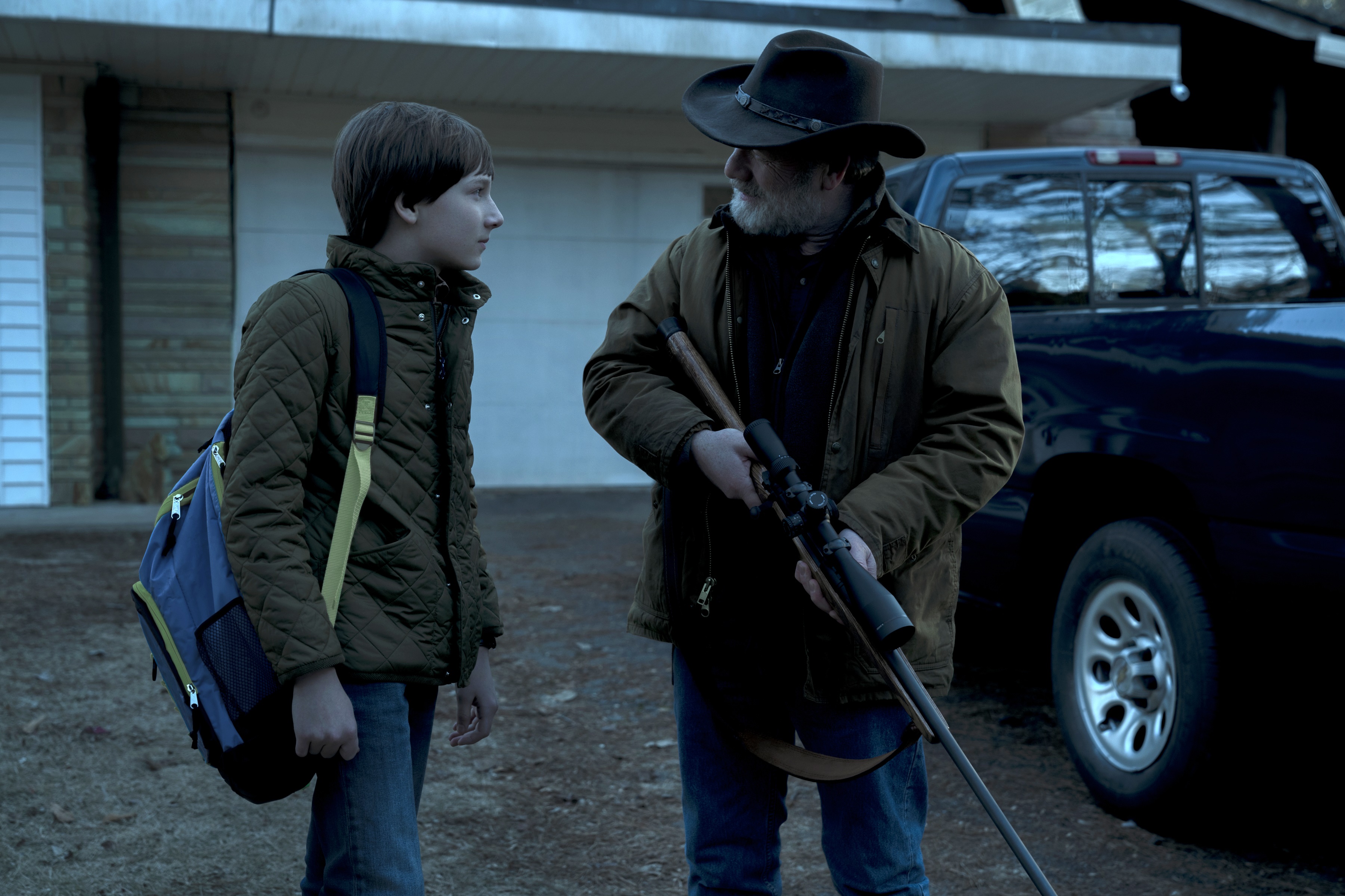 Boy with backpack and man with rifle HD Wallpaper