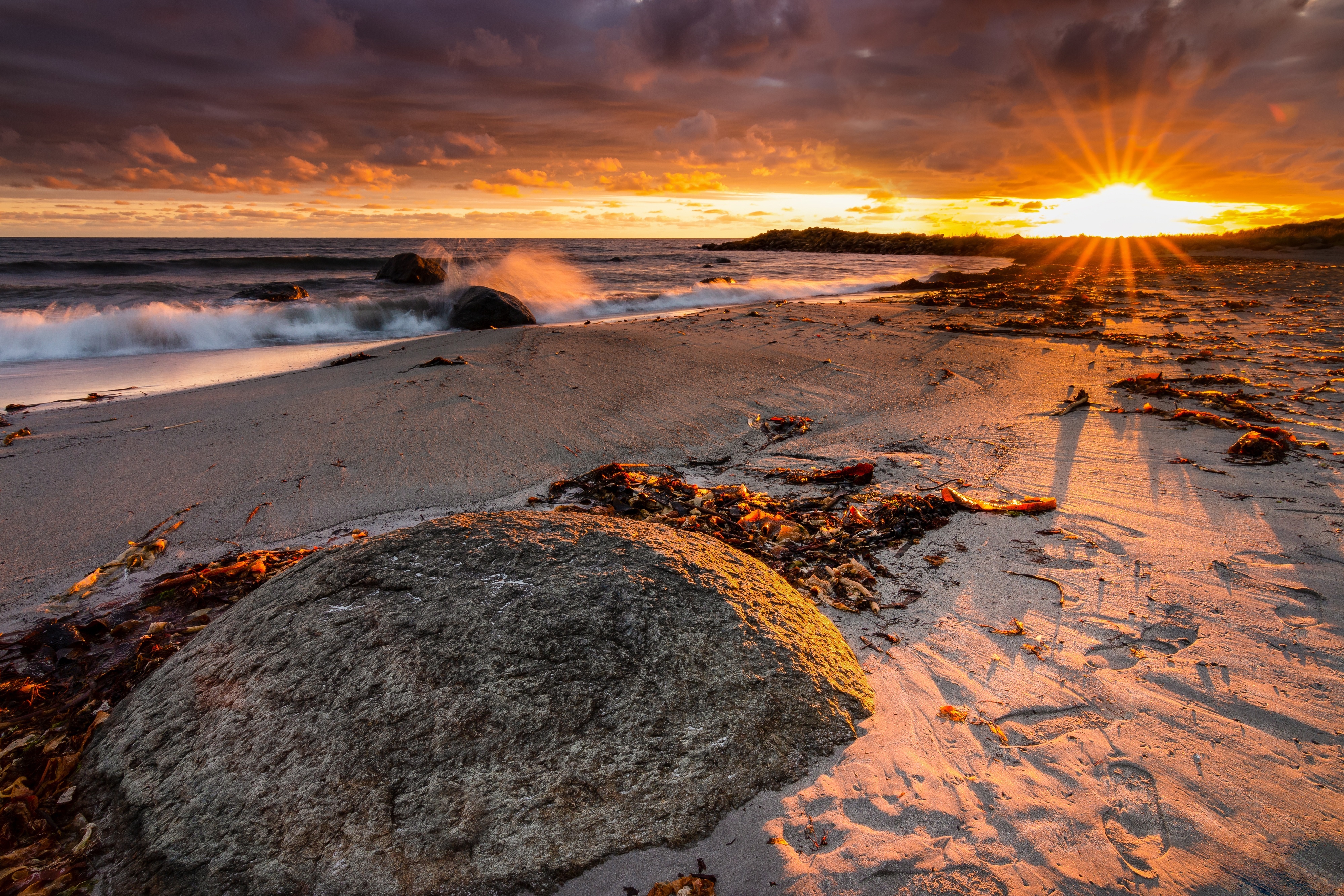 Sunset over a beach with waves and rocks HD Wallpaper