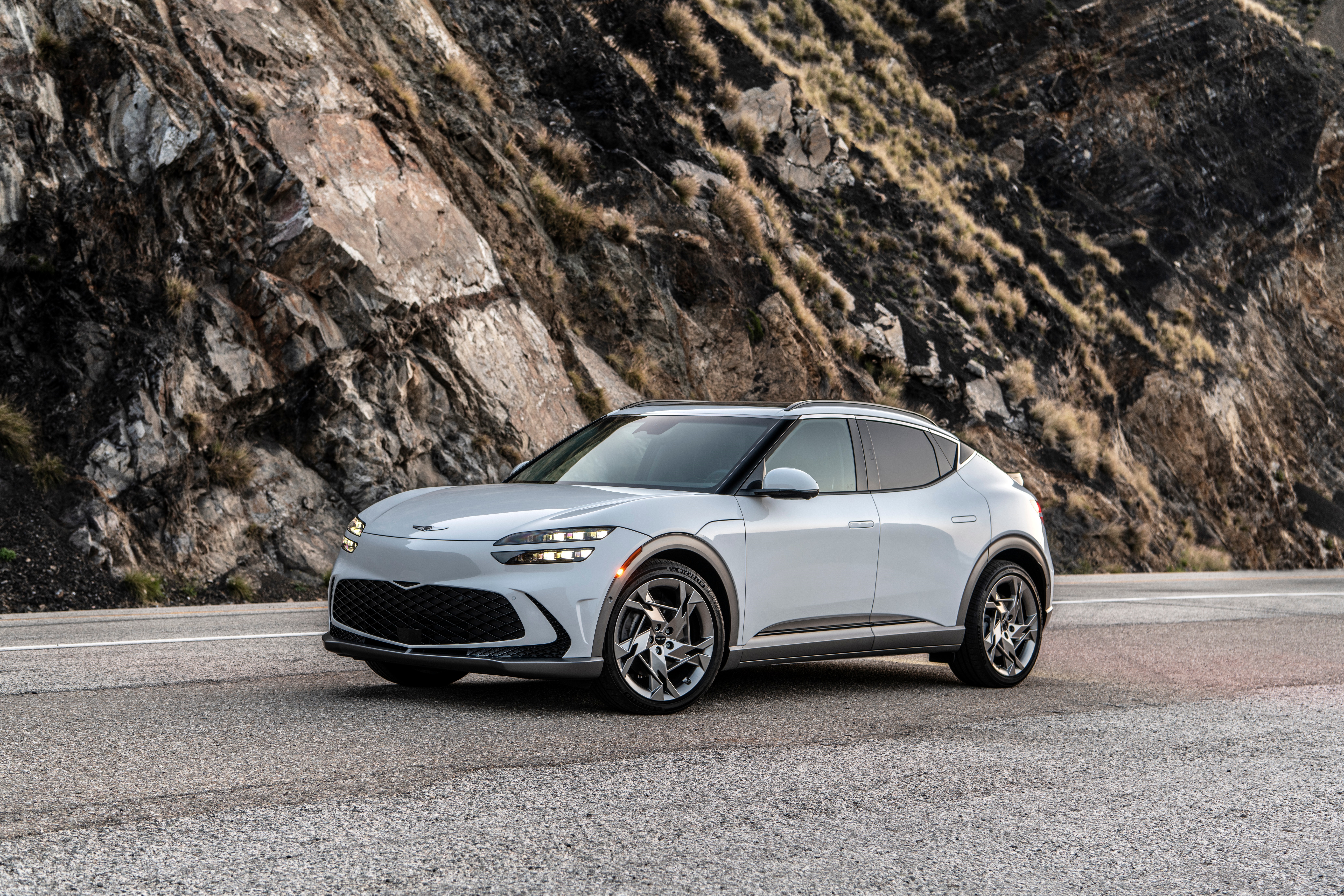 Genesis GV60 electric SUV on a road HD Wallpaper