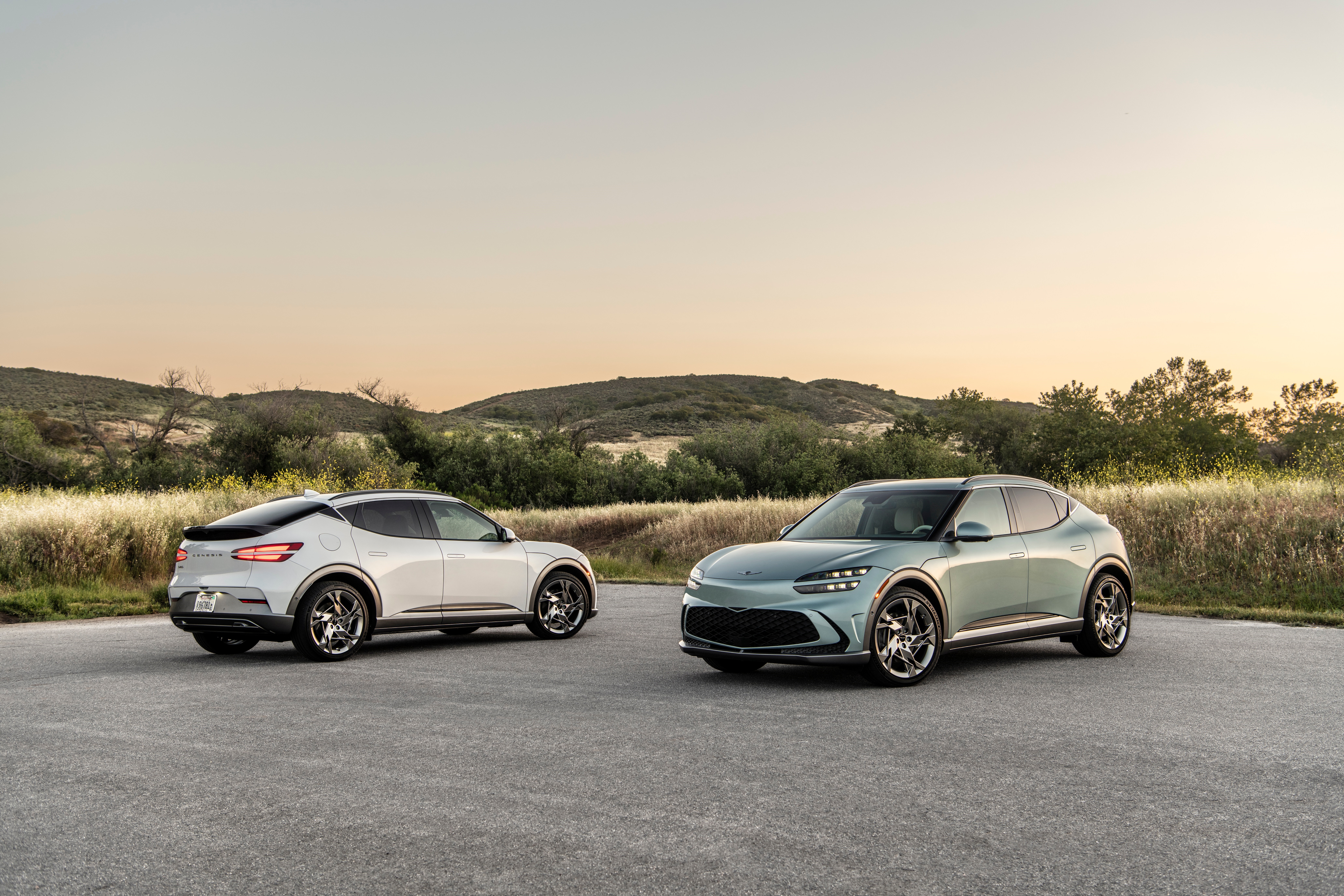 Genesis GV60 electric SUVs in a landscape HD Wallpaper