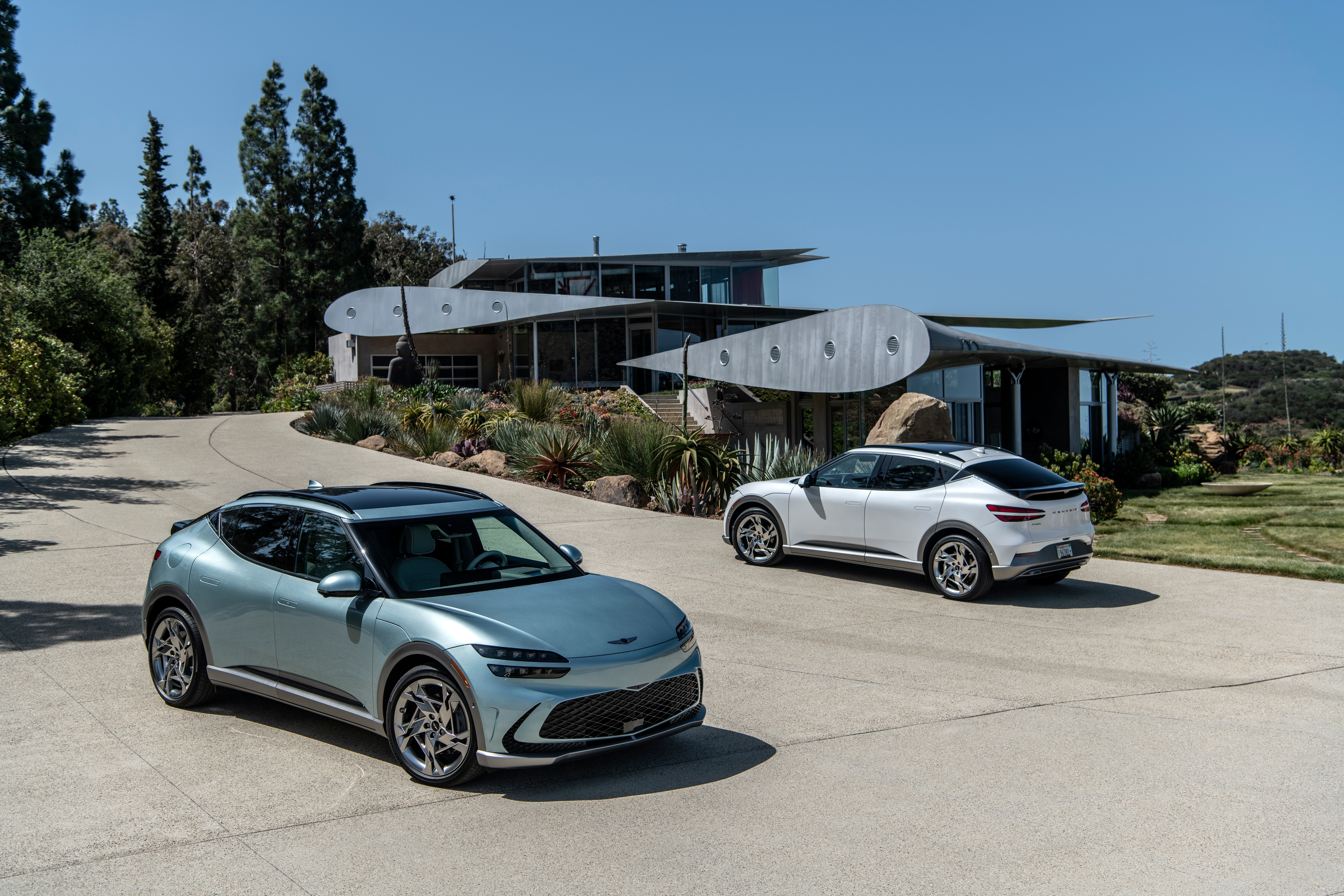 Genesis GV60 electric cars in front of modern house HD Wallpaper