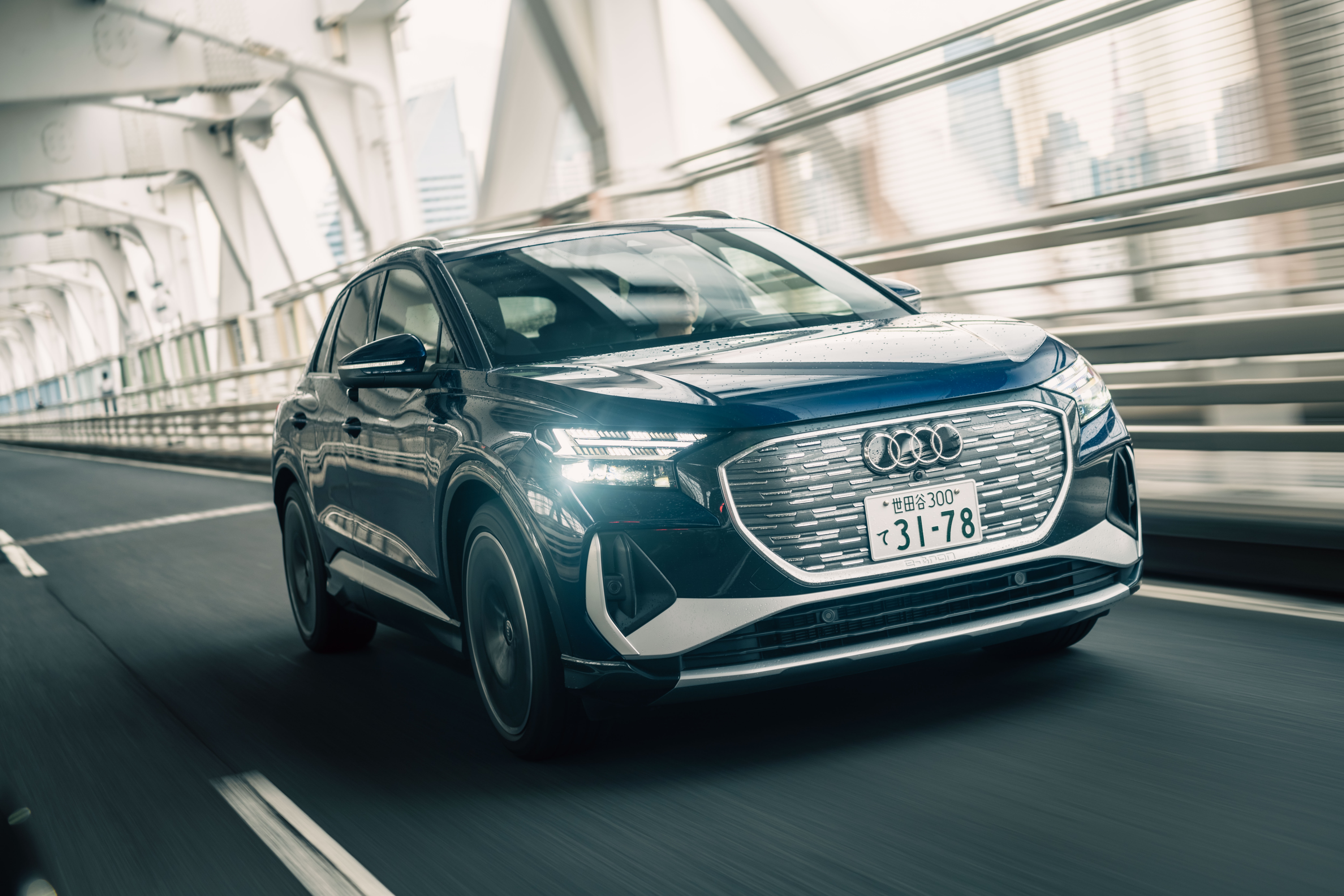 Audi Q4 E-tron driving on a bridge HD Wallpaper