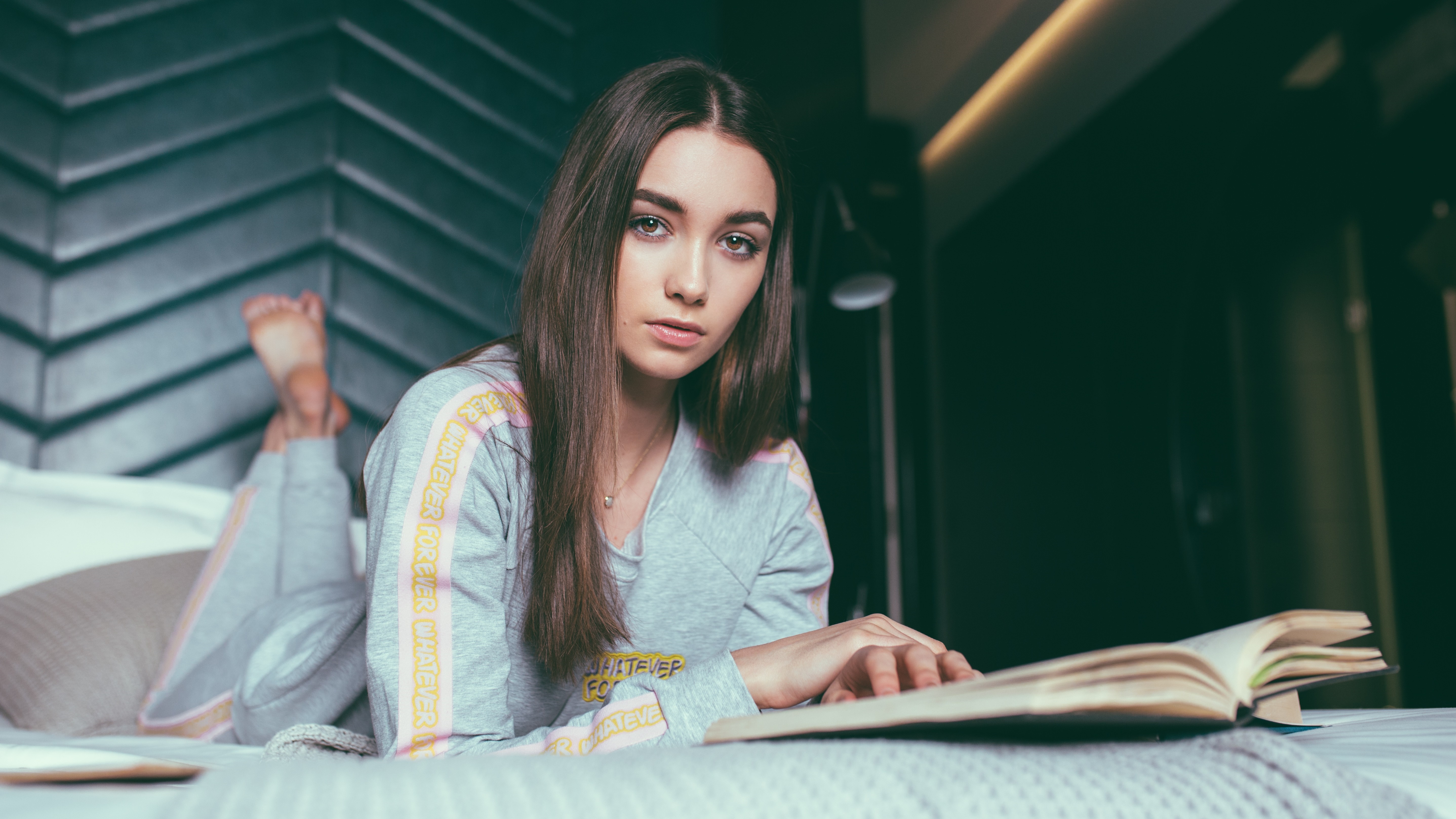 Brunette woman reading a book on a bed HD Wallpaper