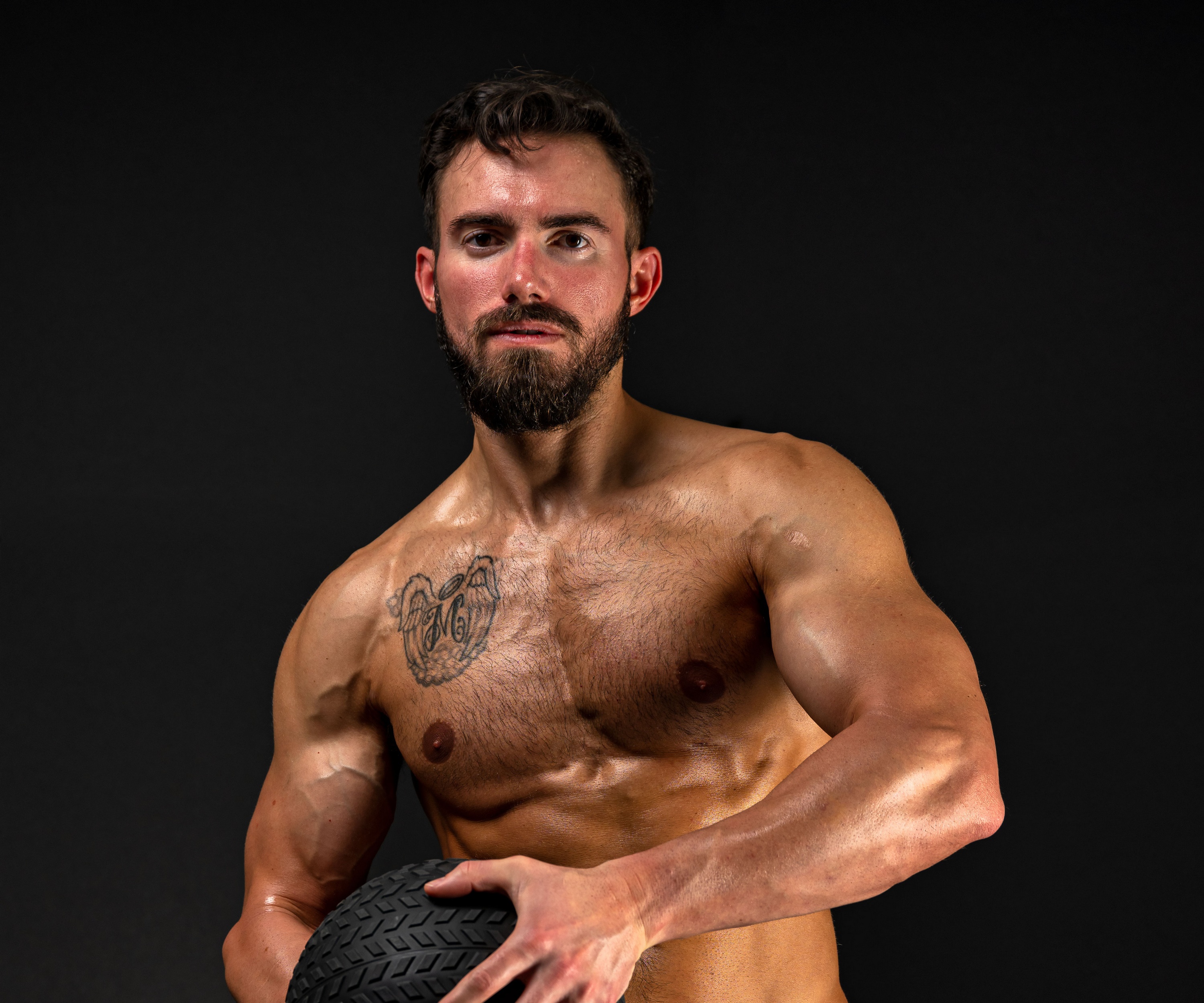 Shirtless man with beard holding a tire HD Wallpaper