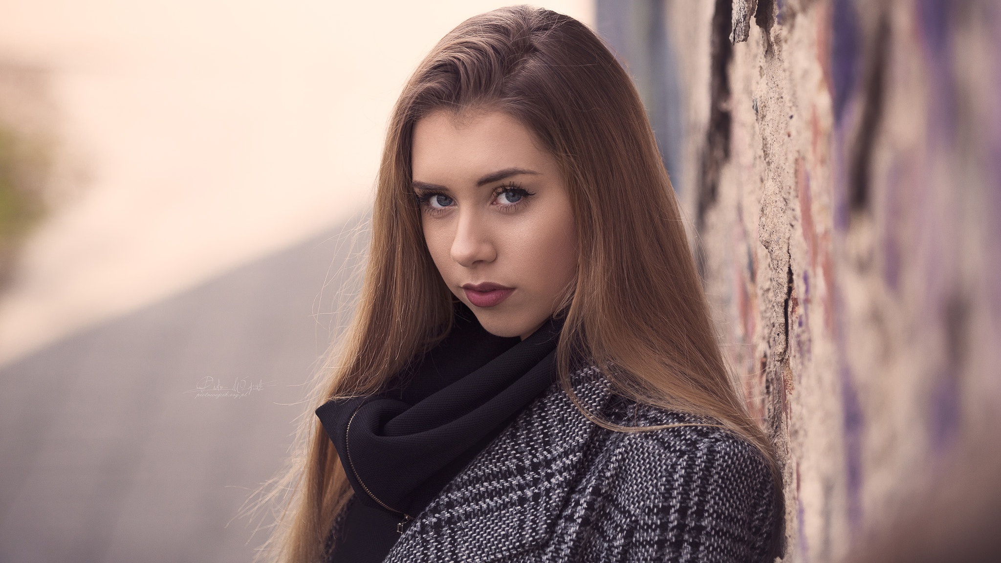 Young woman with long brown hair leaning against a wall HD Wallpaper
