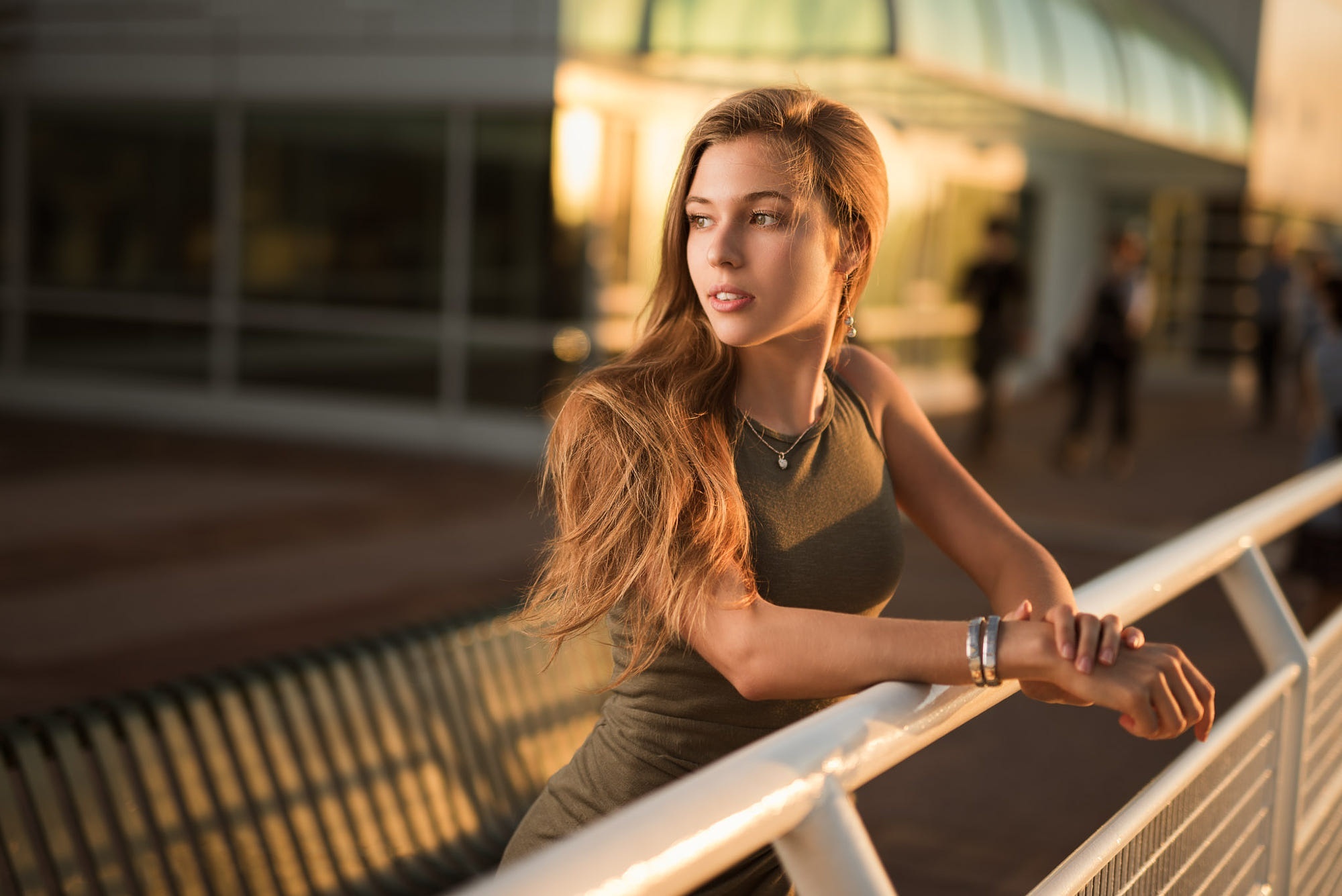 Young woman leaning on a railing outdoors HD Wallpaper