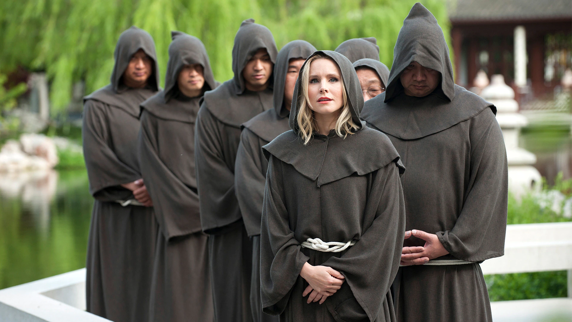 Kristen Bell with monks in a garden HD Wallpaper