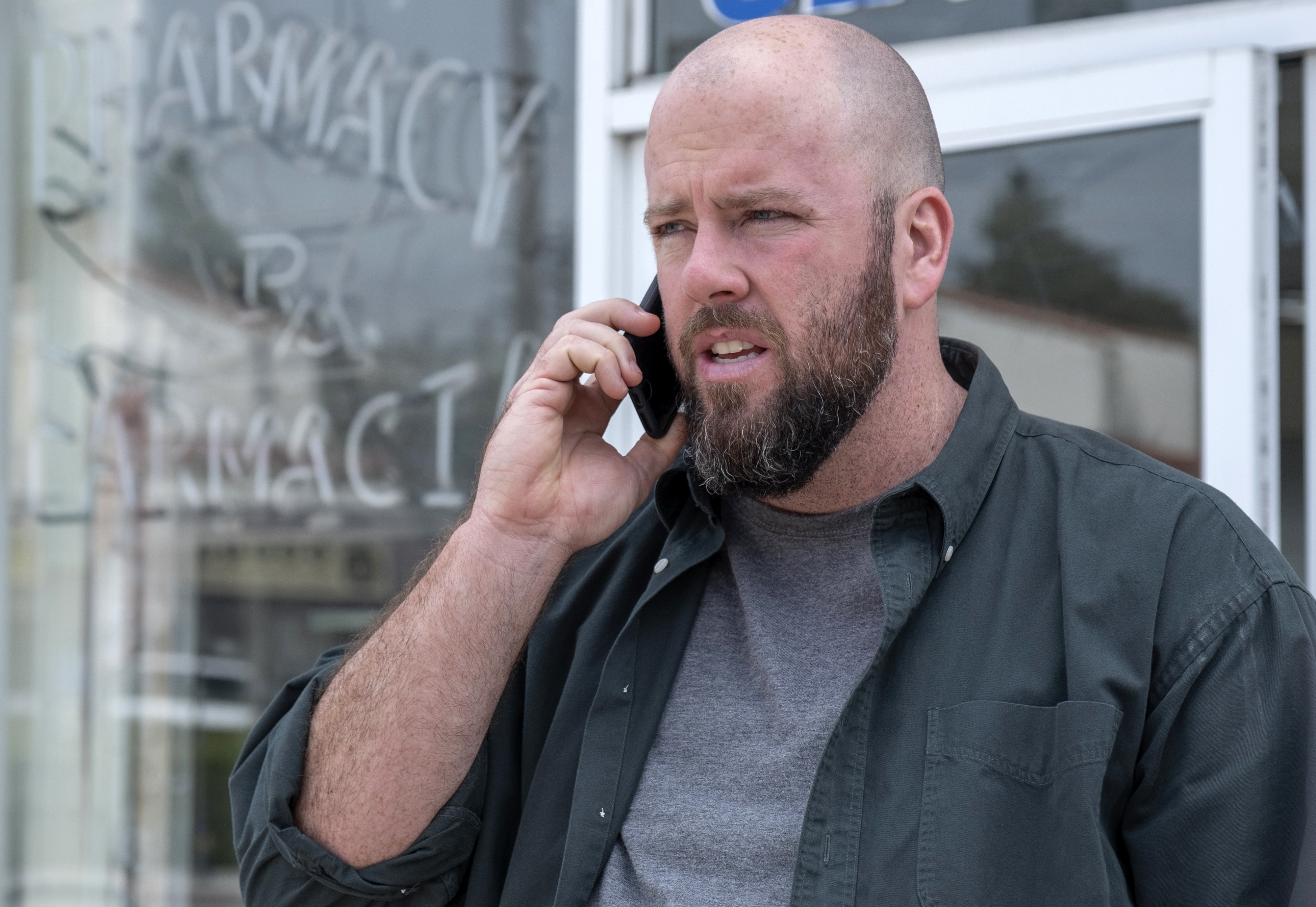 Man talking on phone in front of pharmacy HD Wallpaper