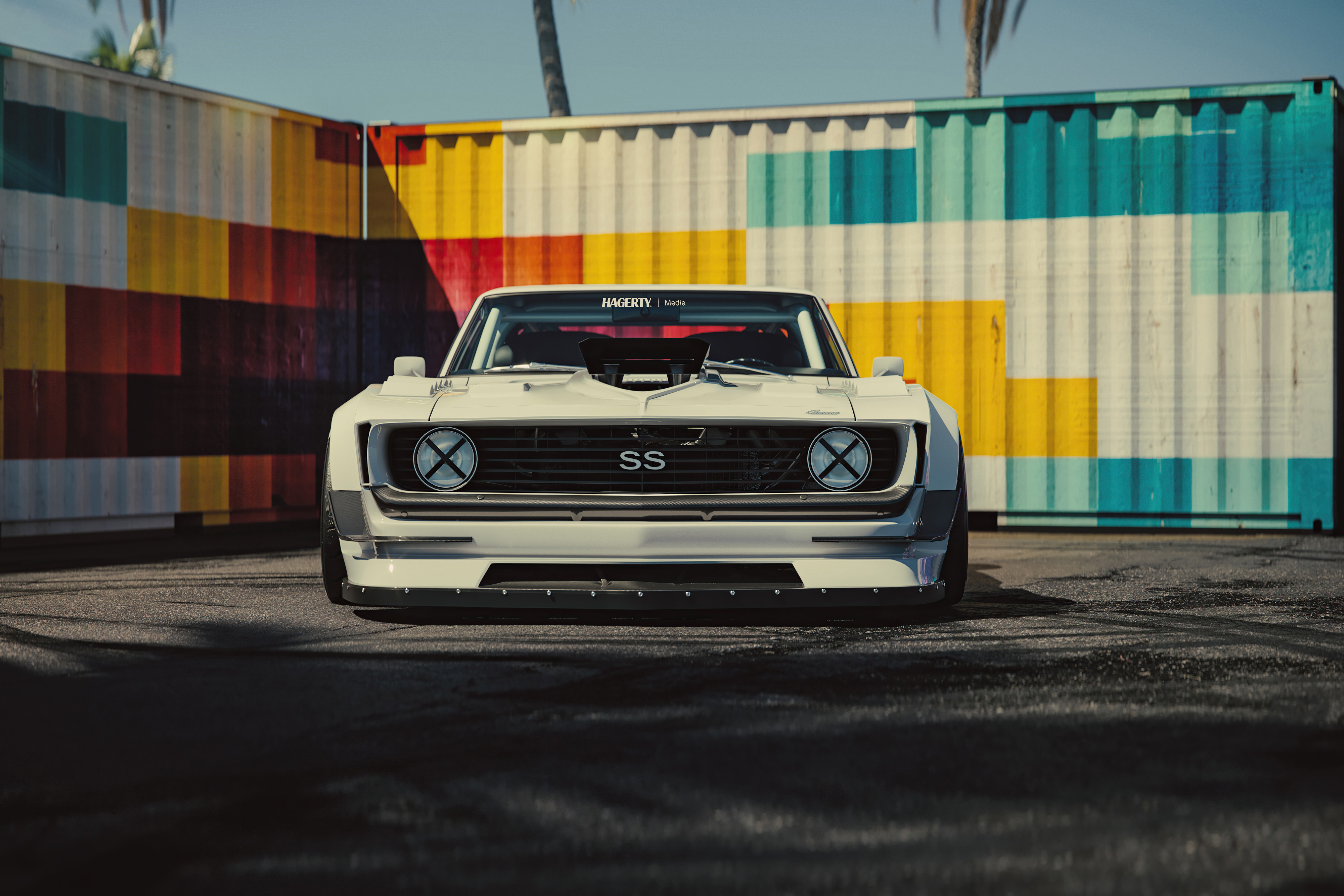 White Chevrolet Camaro SS in front of colorful shipping containers HD Wallpaper