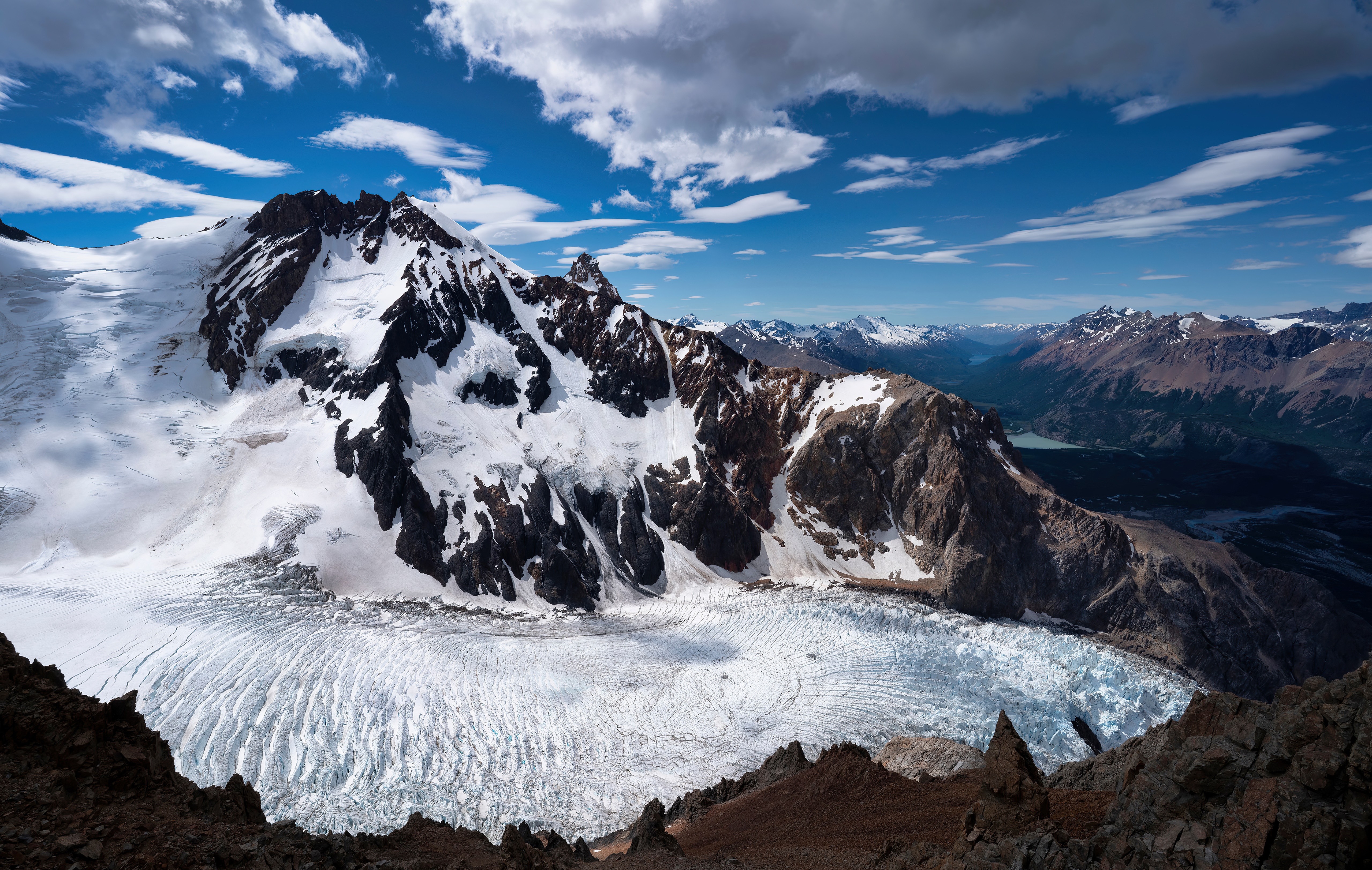 Snowy mountains and glacier under a cloudy blue sky HD Wallpaper