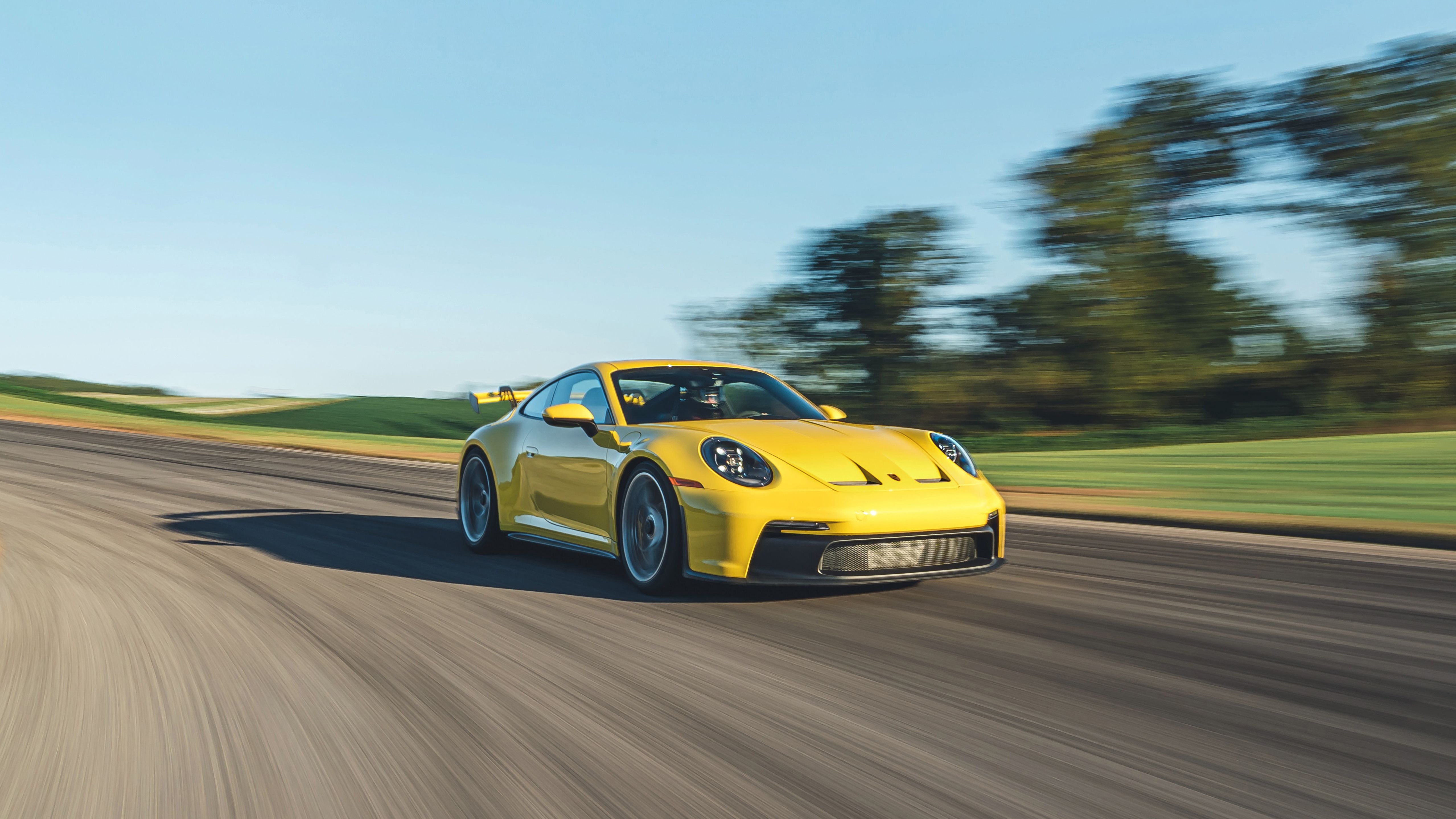 Yellow Porsche 911 GT3 driving on a track HD Wallpaper