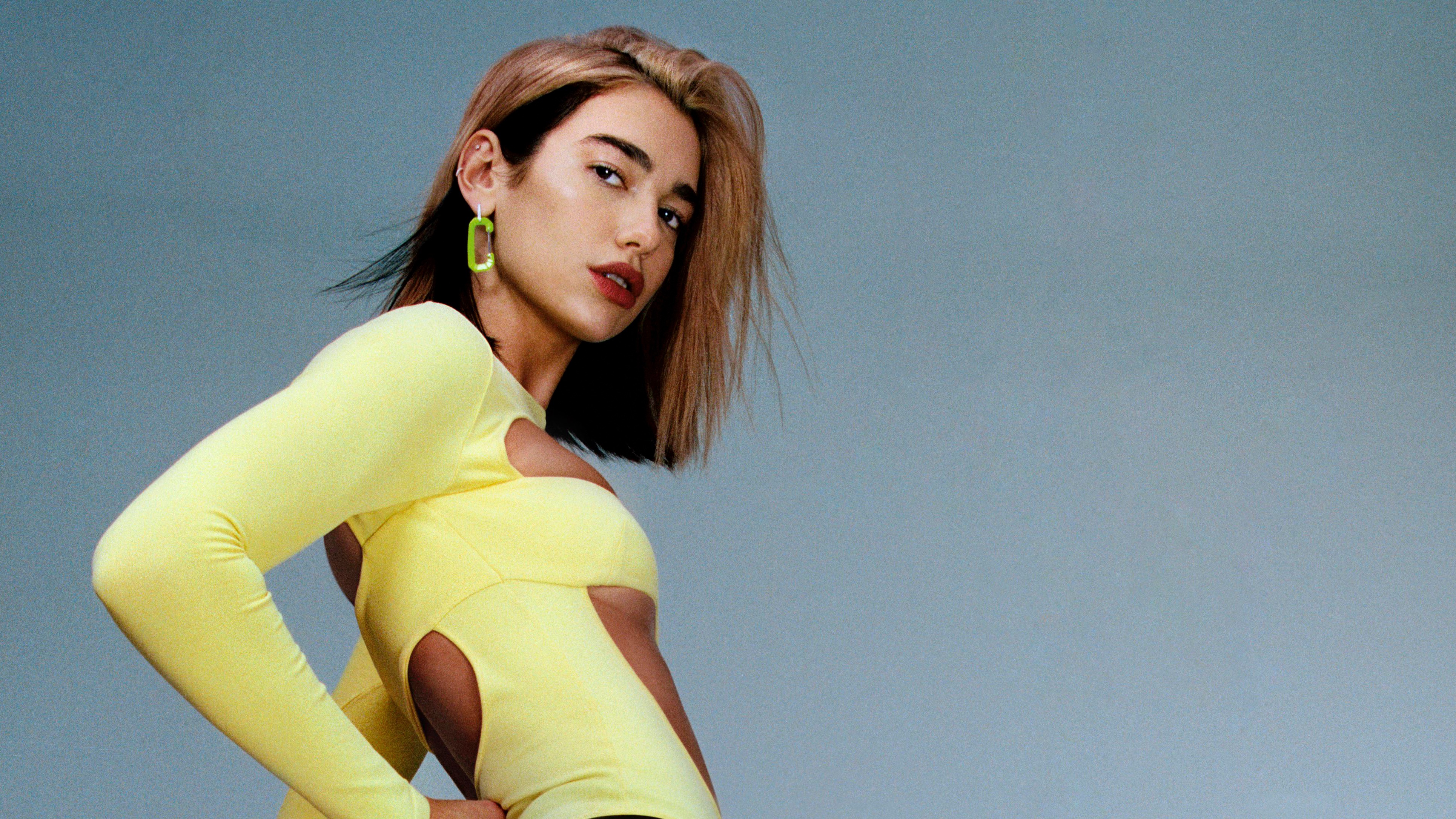 Dua Lipa in yellow outfit with green earrings HD Wallpaper