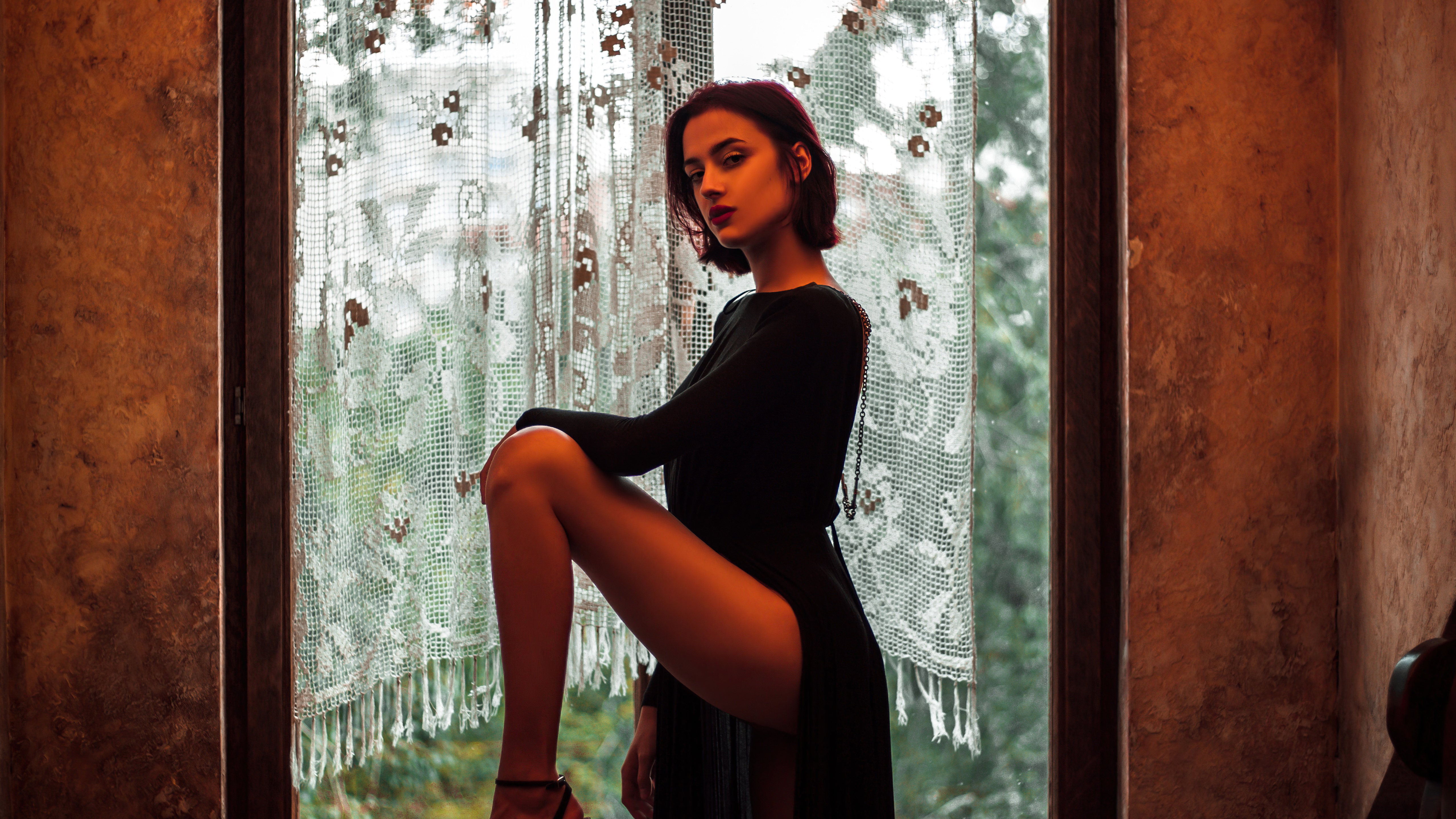 Model in a black dress posing by a window HD Wallpaper