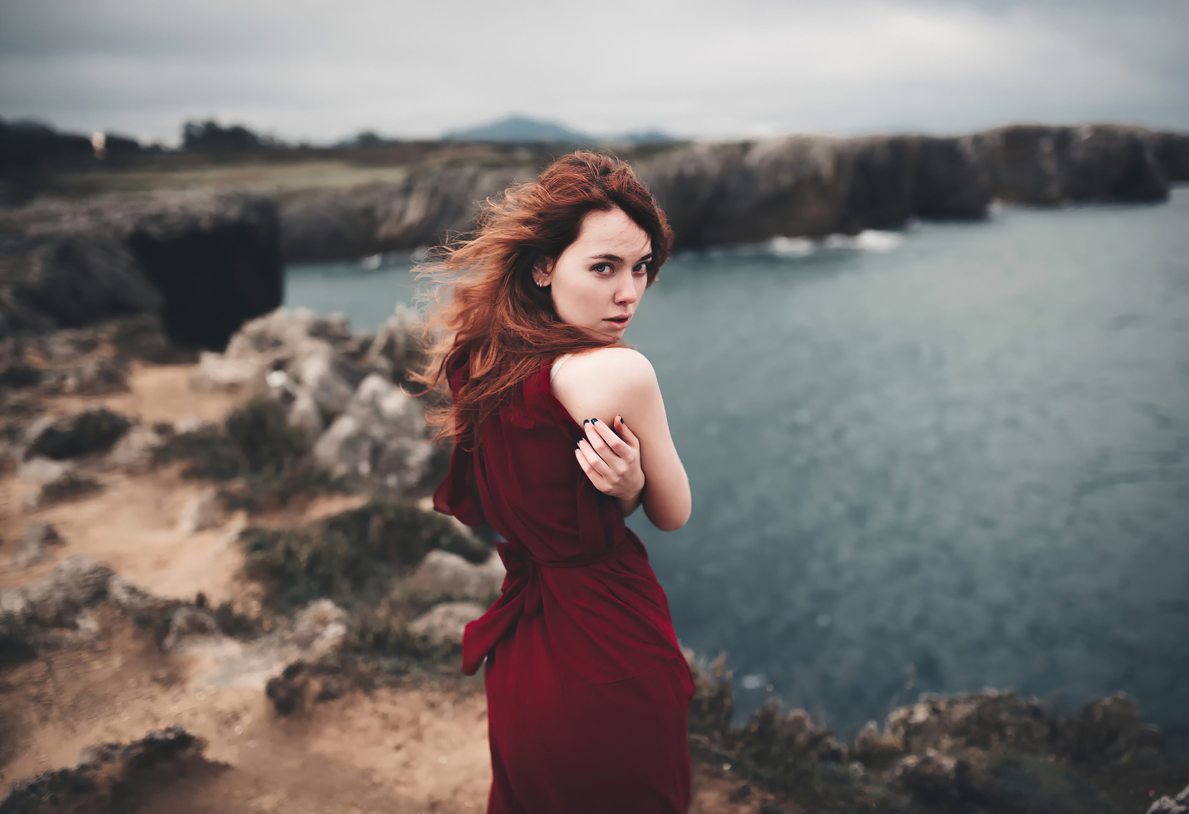 Redhead woman in red dress on cliff by the sea HD Wallpaper
