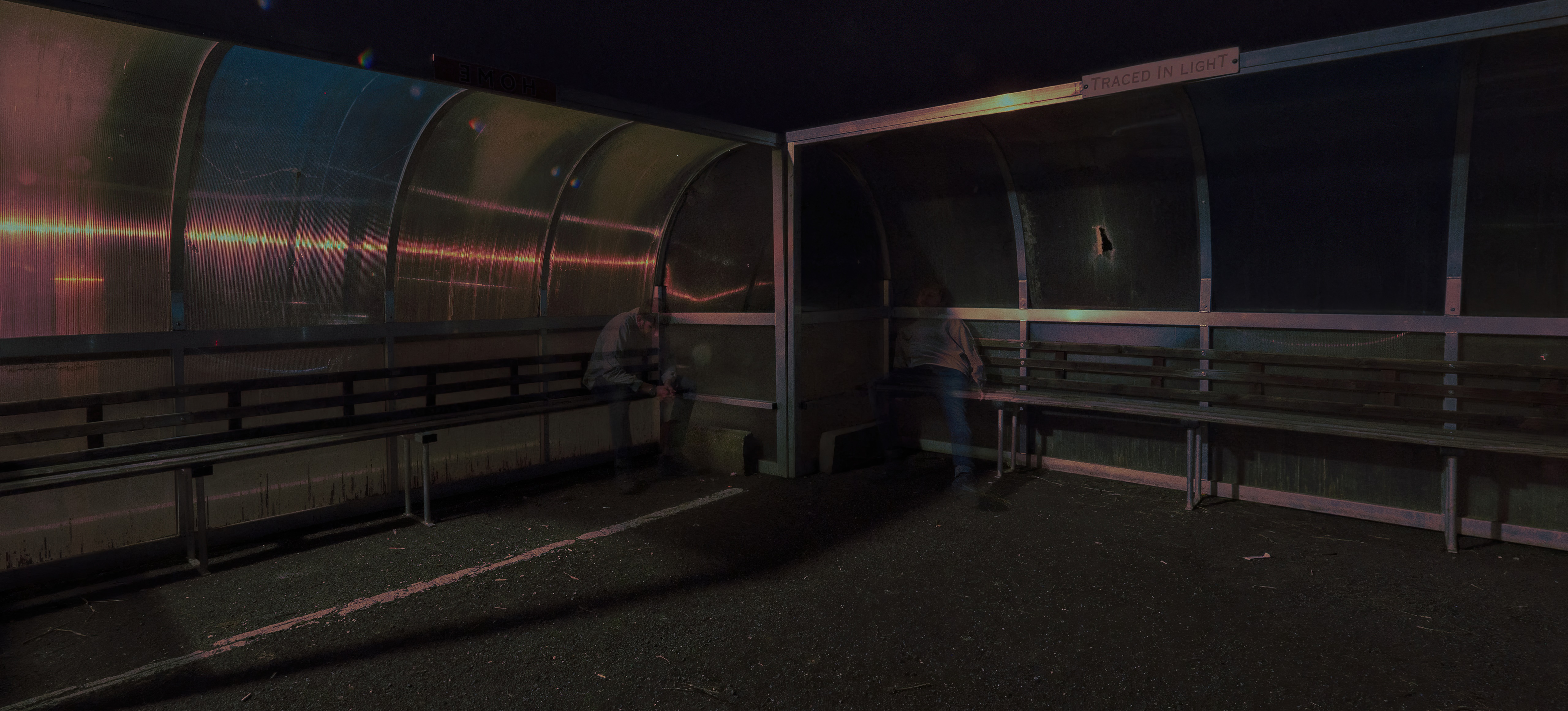 Two people in a covered shelter at night HD Wallpaper