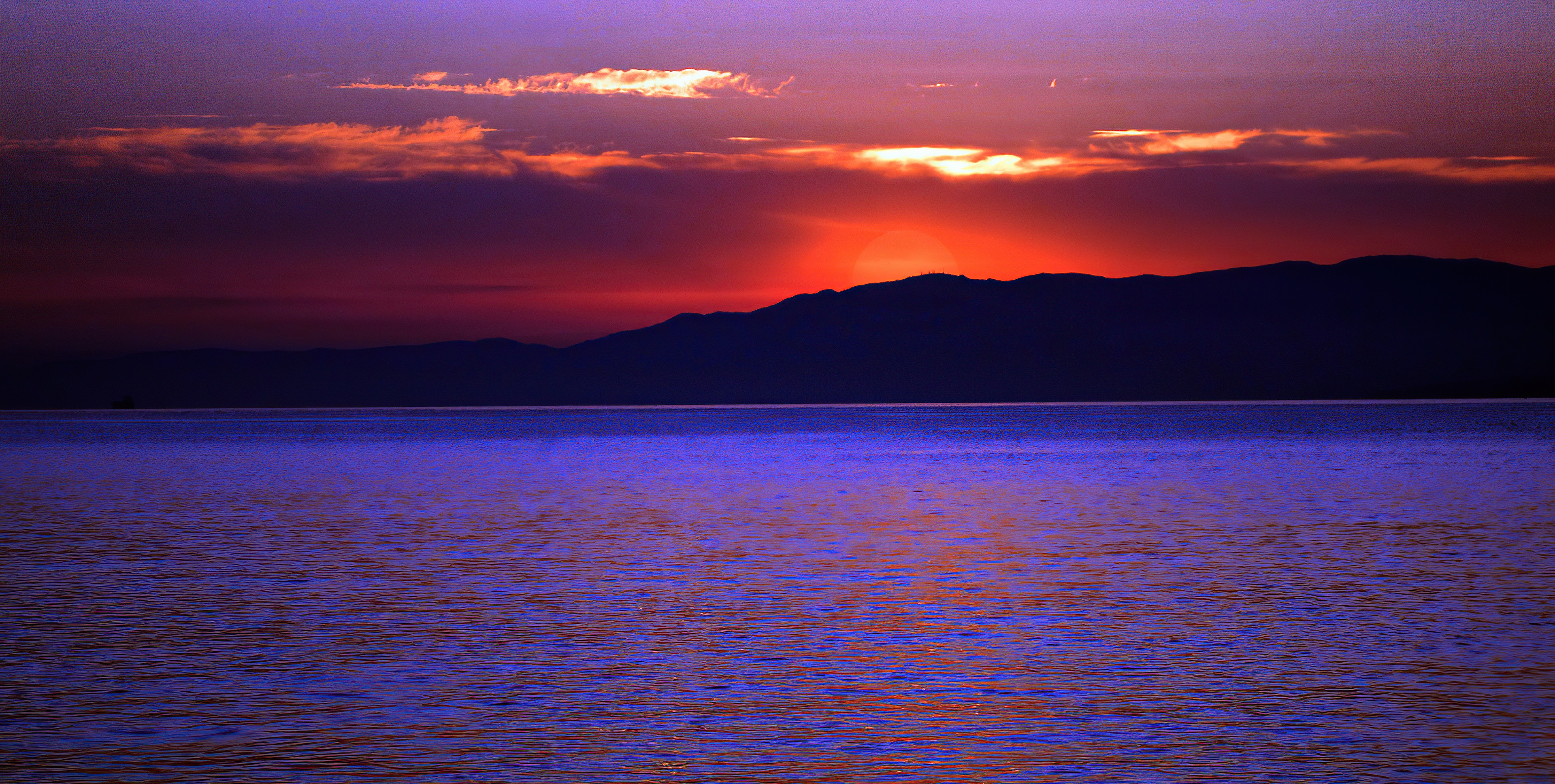 Sunset over the ocean with mountains HD Wallpaper