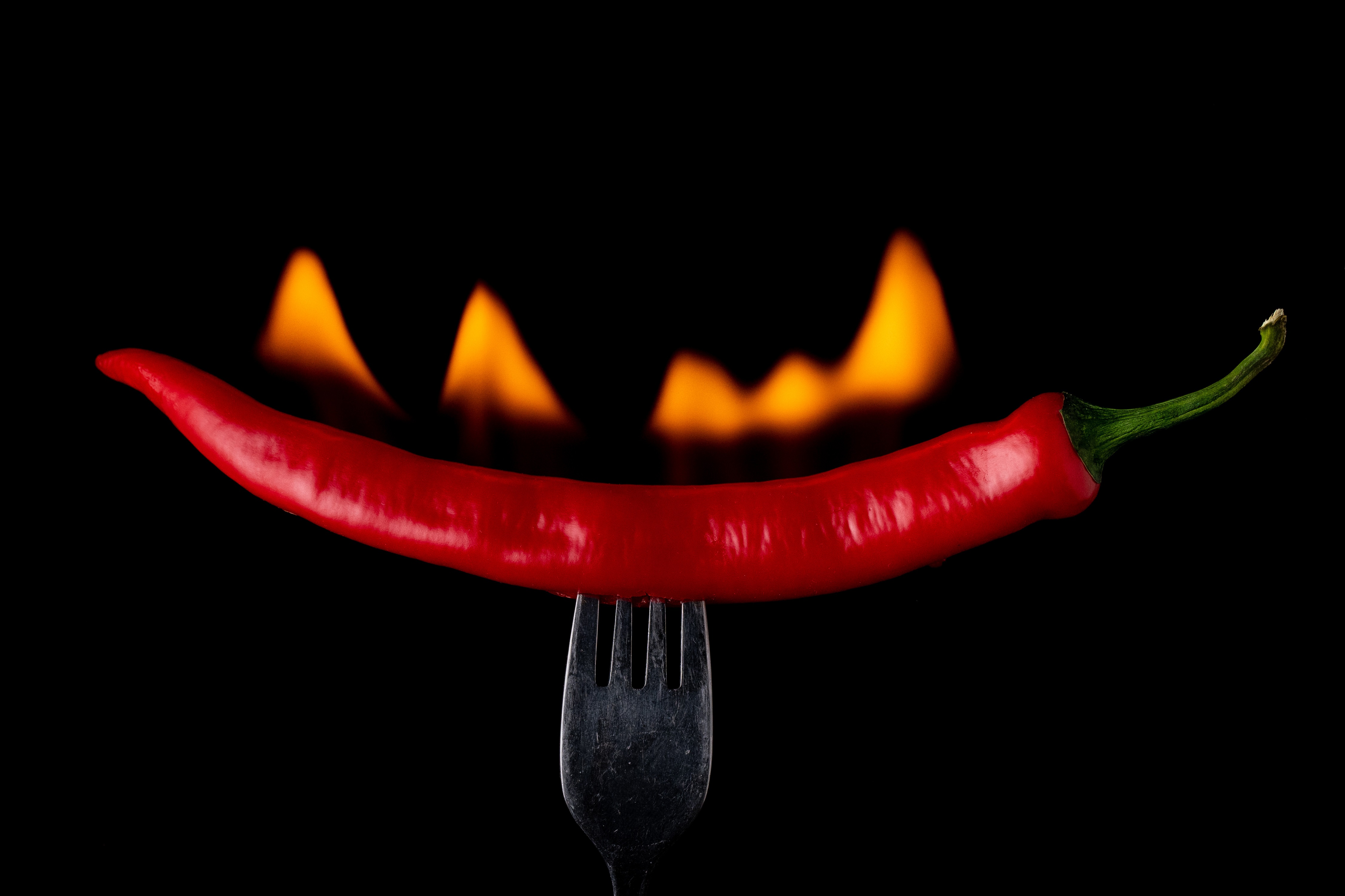 Red chili pepper on a fork with fire HD Wallpaper