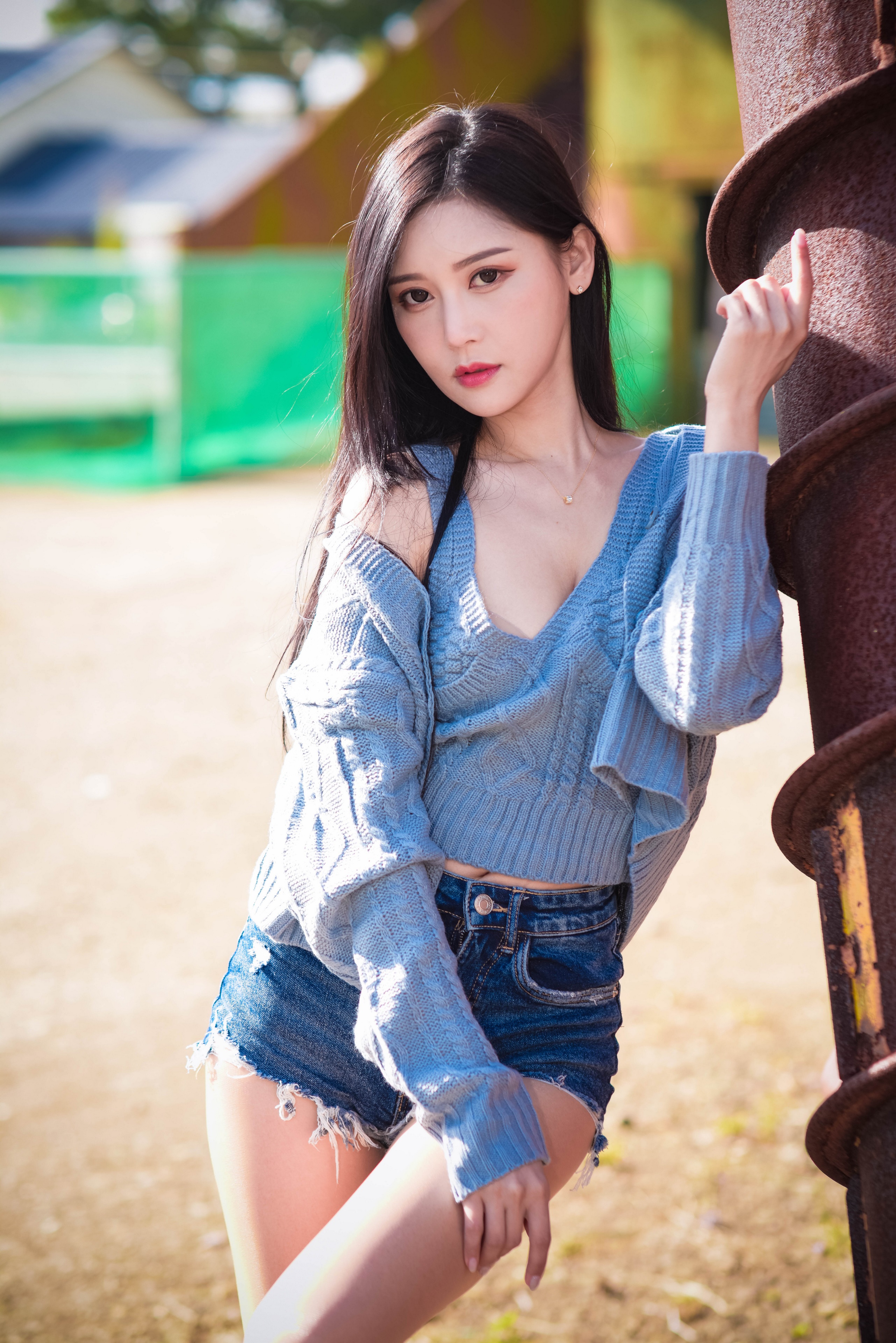 Asian woman in blue sweater and denim shorts posing outdoors HD Phone Wallpaper
