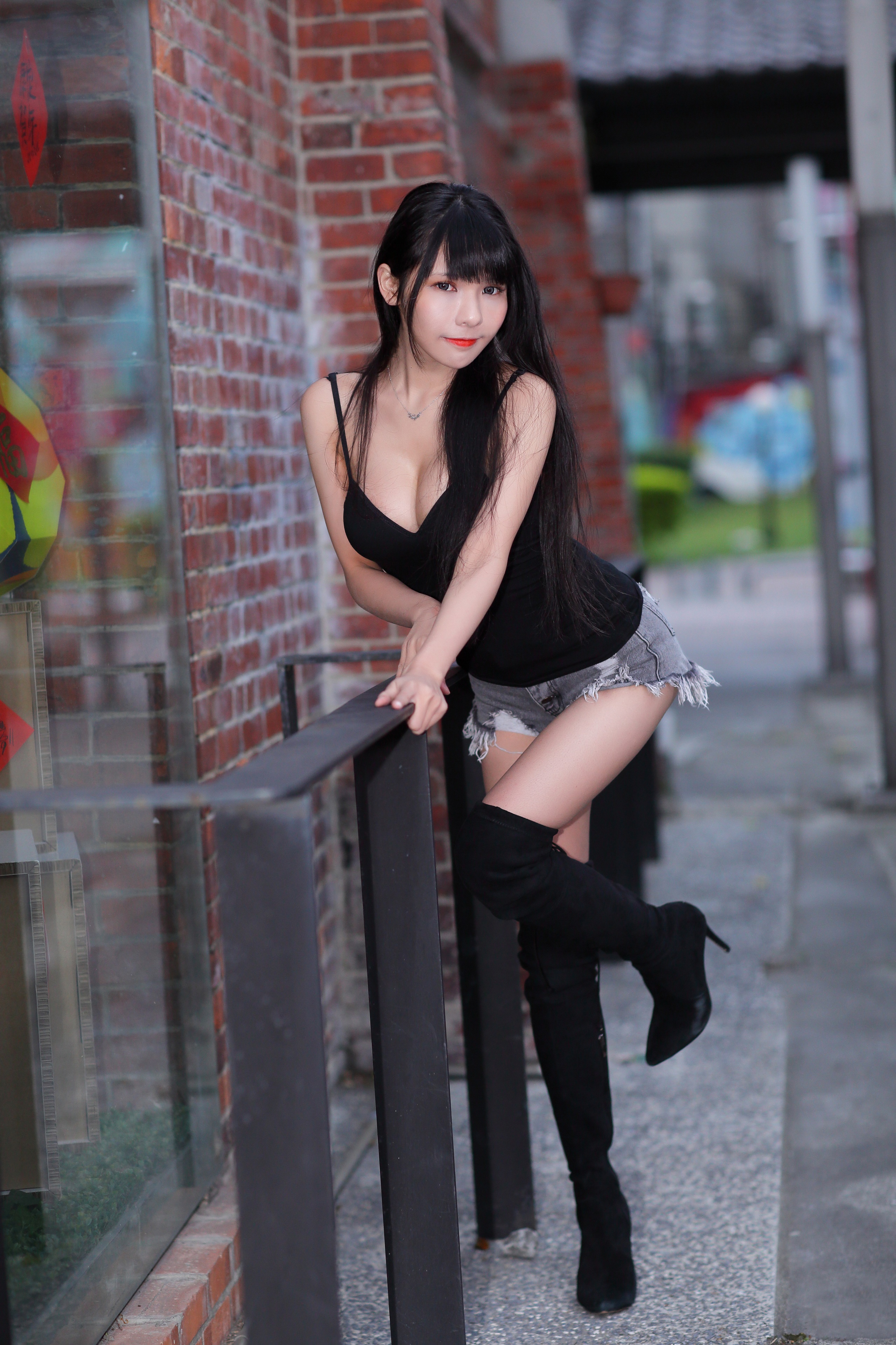 Brunette girl in shorts and boots posing outdoors HD Phone Wallpaper