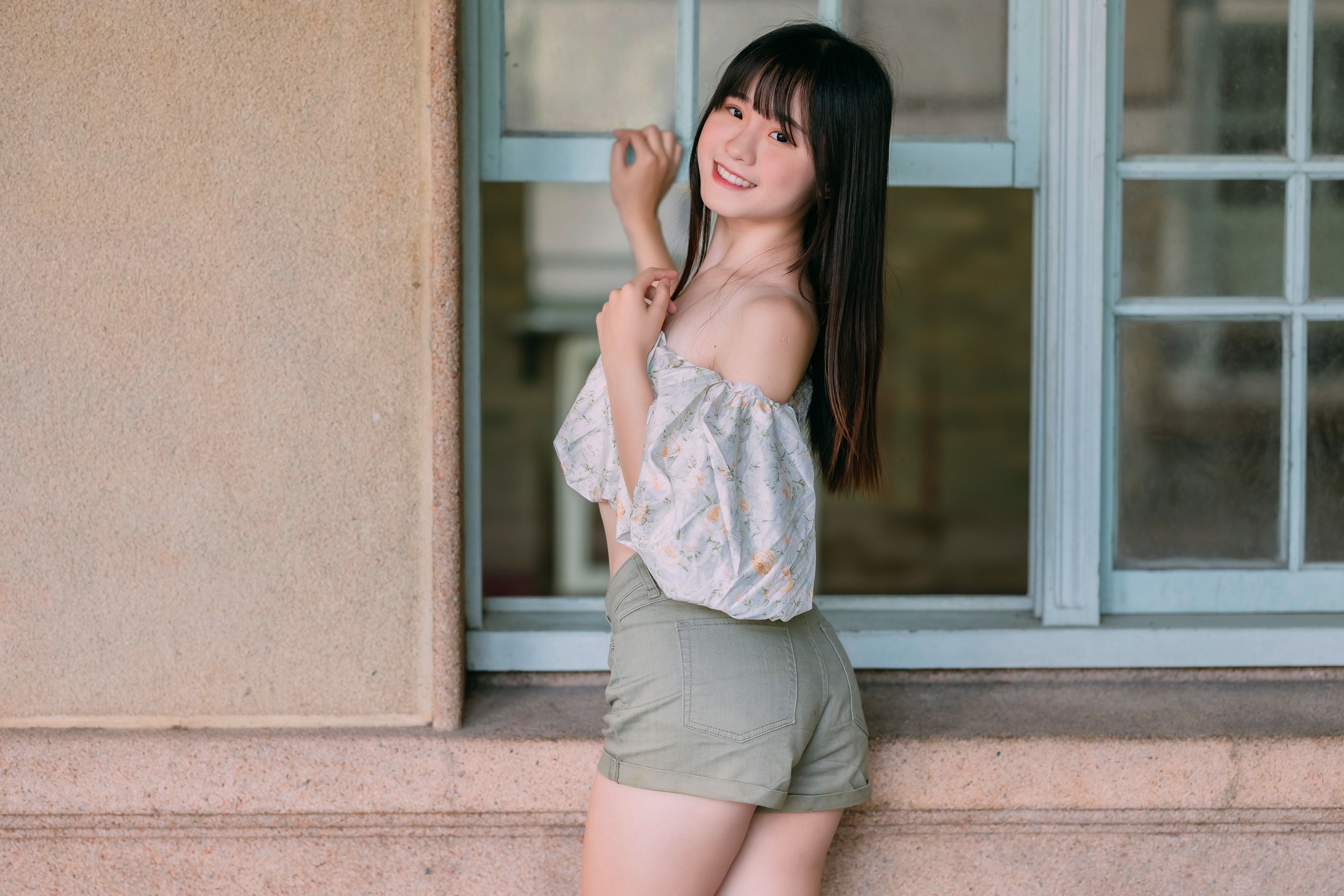 Asian girl in shorts and blouse posing by window HD Wallpaper