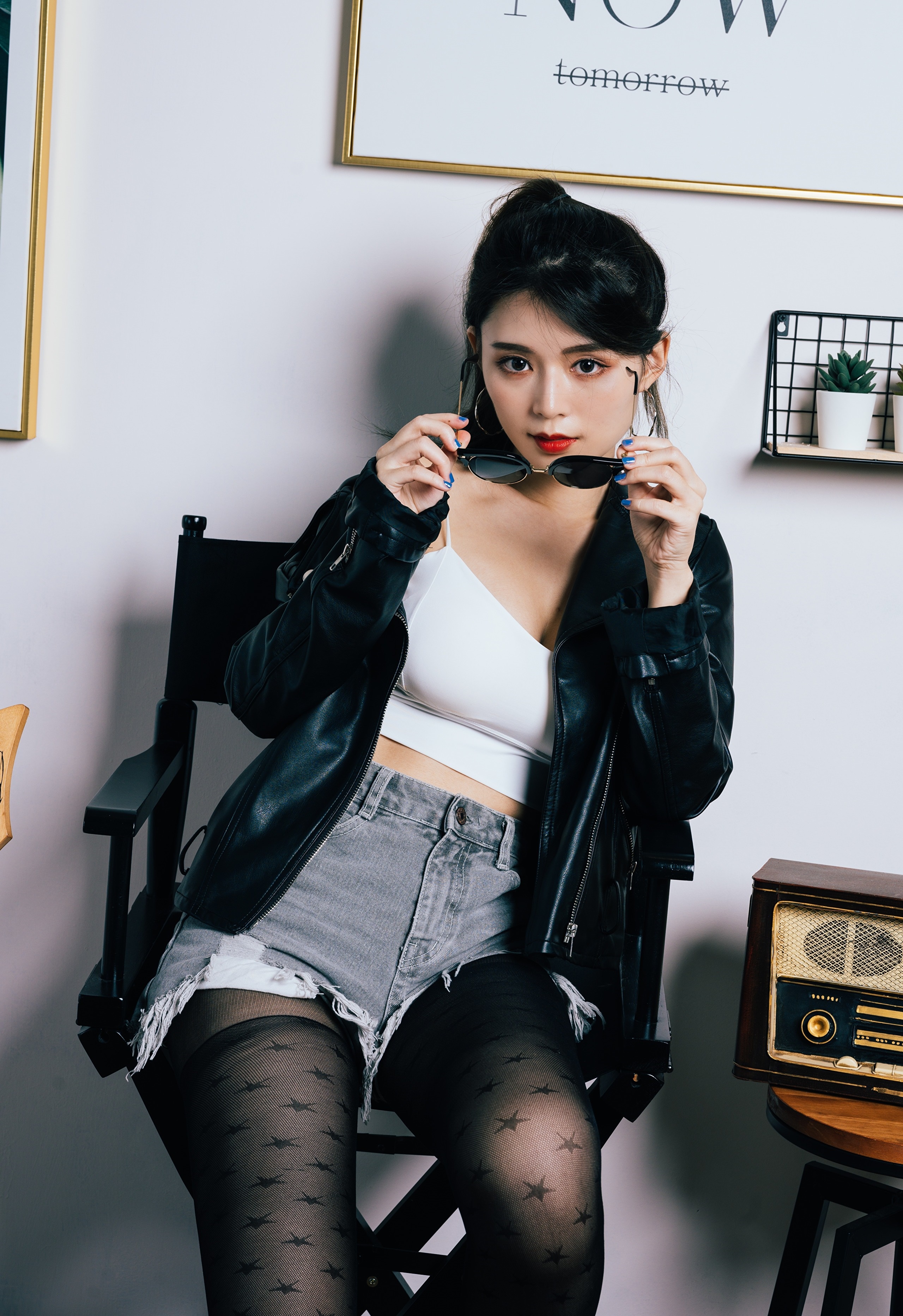 Asian woman in leather jacket and shorts sitting HD Phone Wallpaper