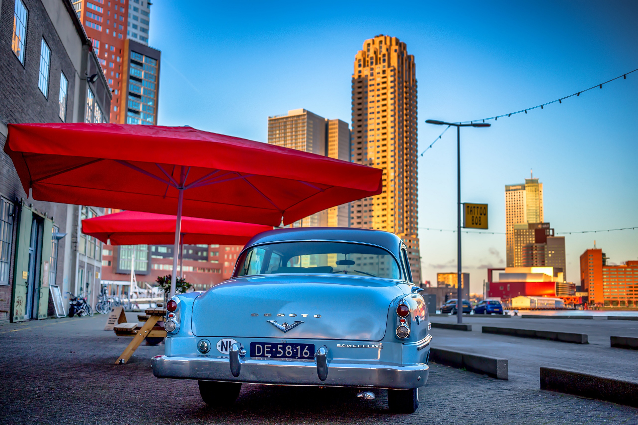 DeSoto car parked near red umbrellas in Rotterdam, Netherlands HD Wallpaper