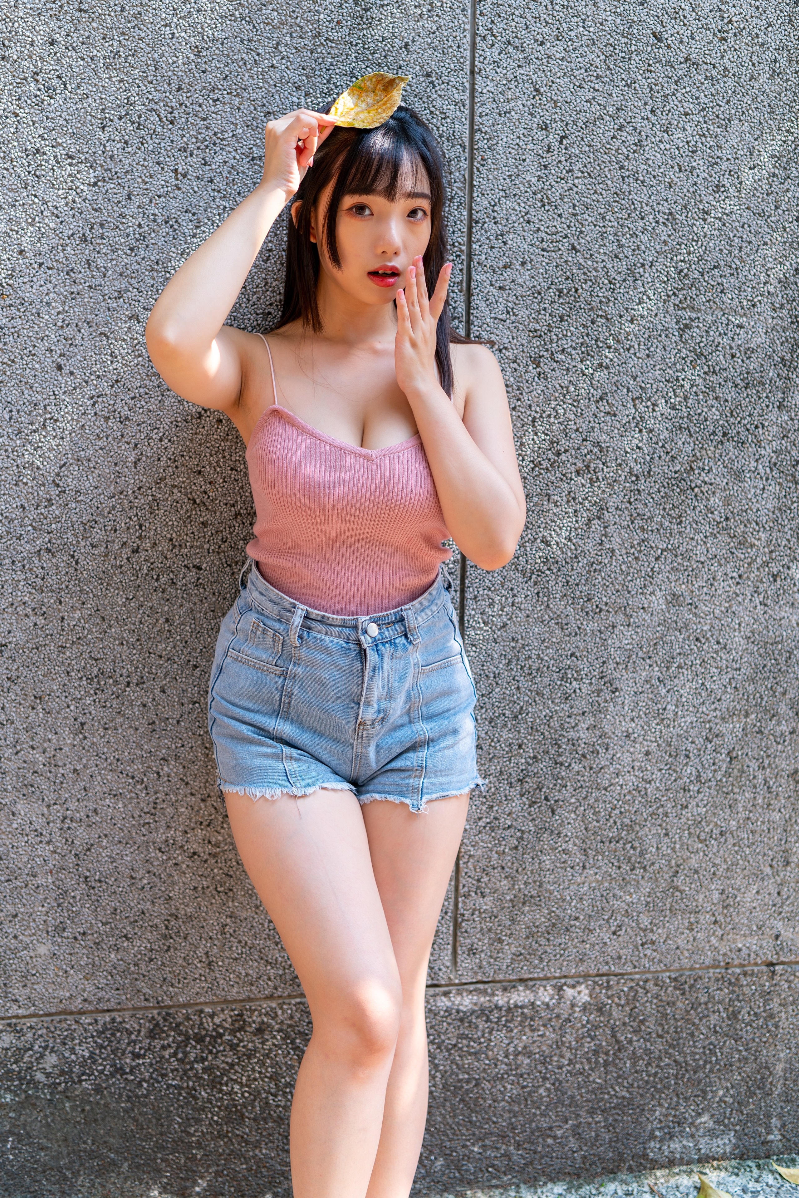 Asian girl in shorts holding a leaf HD Phone Wallpaper