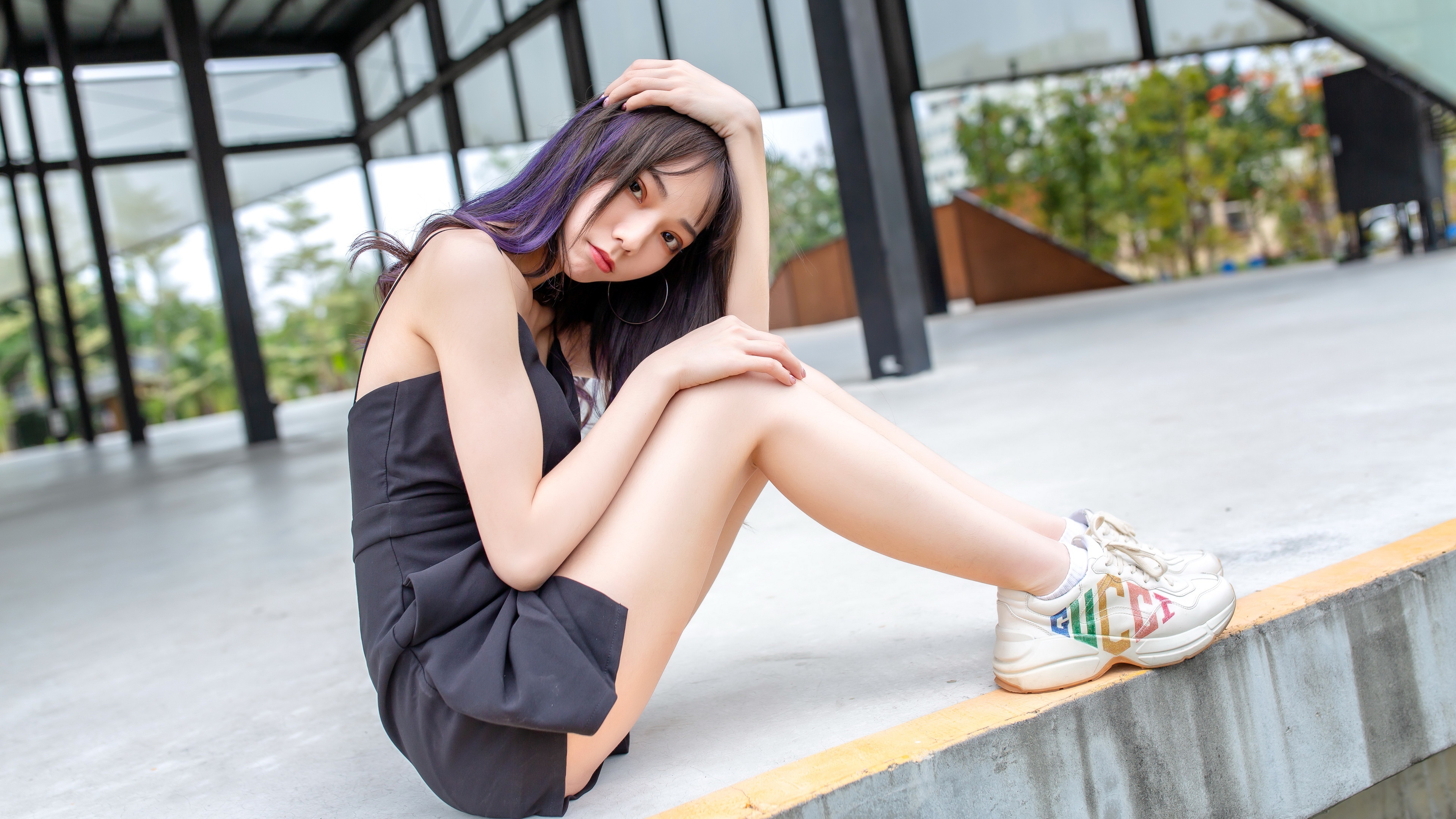 Asian woman in black dress and athletic shoes sitting HD Wallpaper