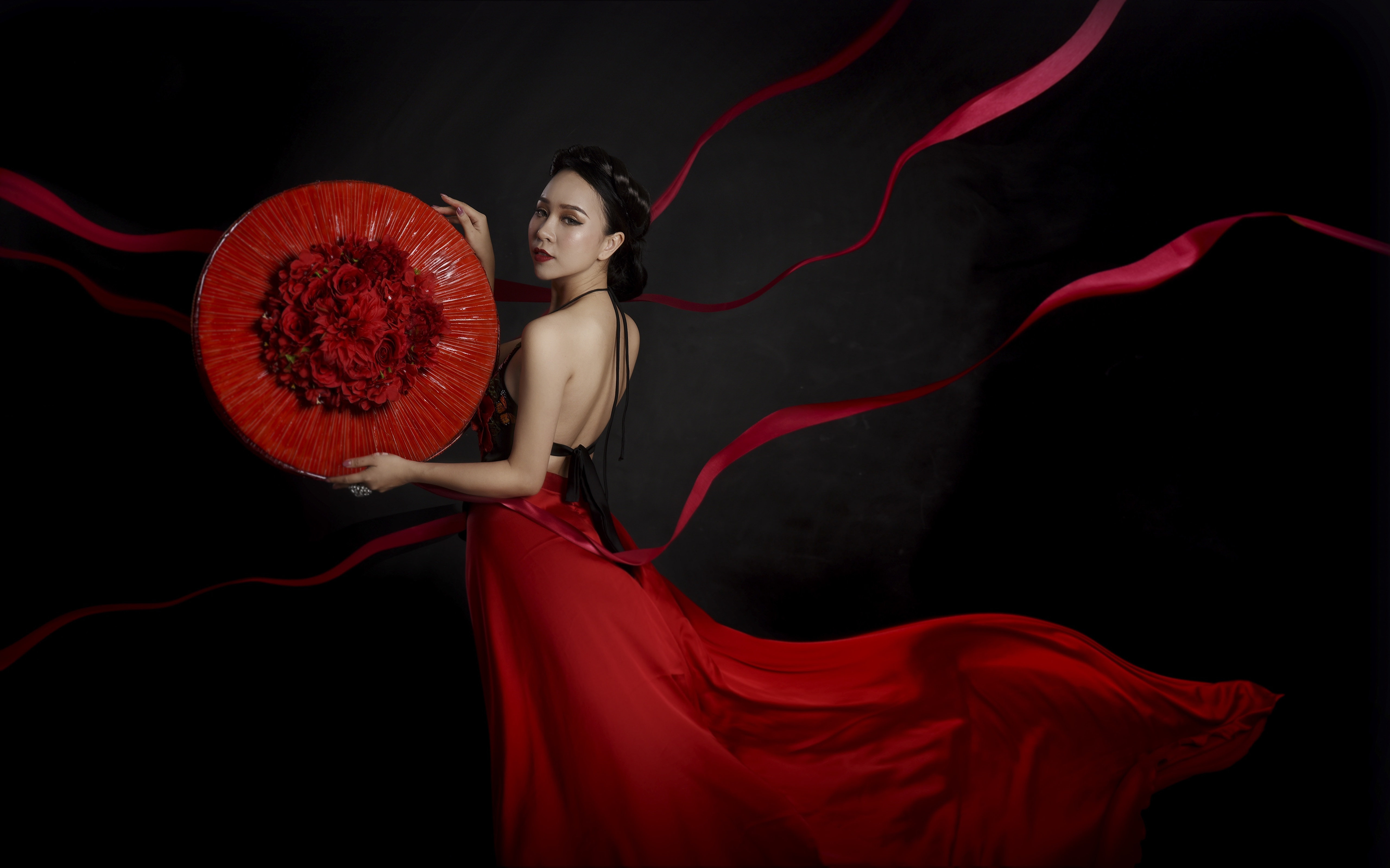 Asian woman in red dress holding floral arrangement HD Wallpaper