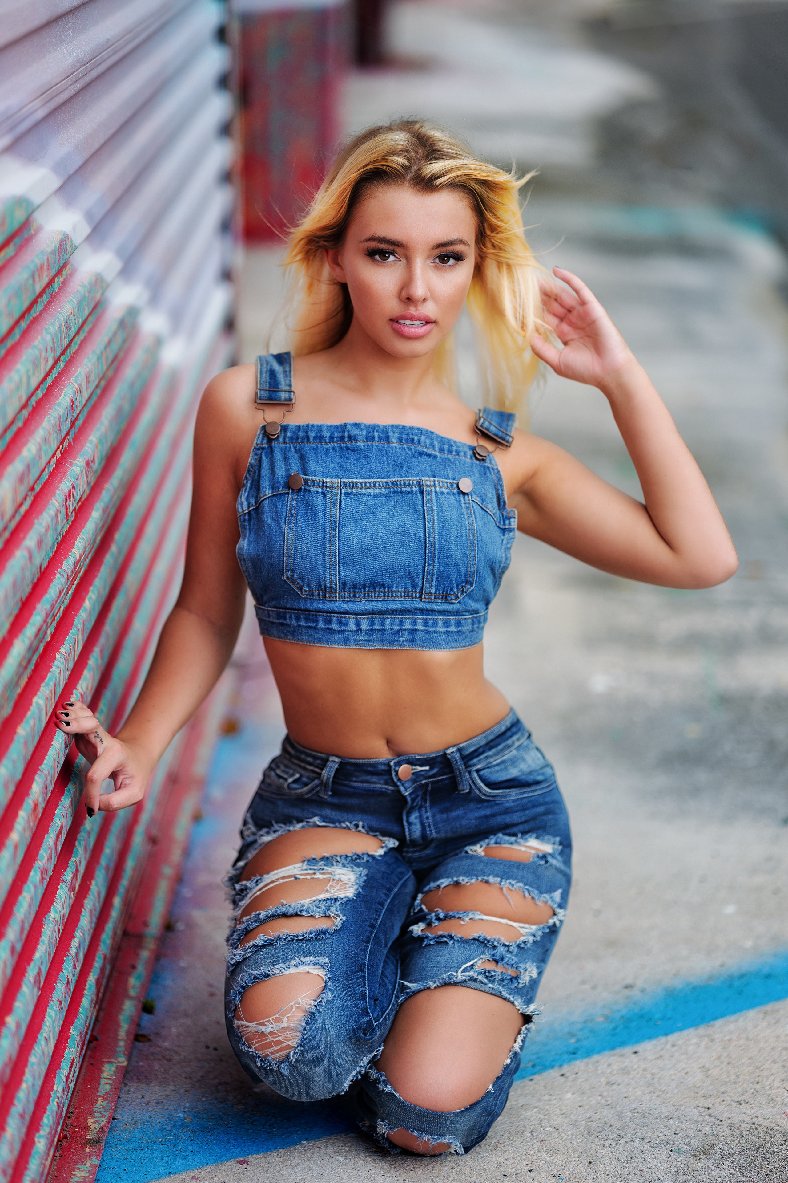 Blonde girl in denim overalls and ripped jeans posing HD Phone Wallpaper