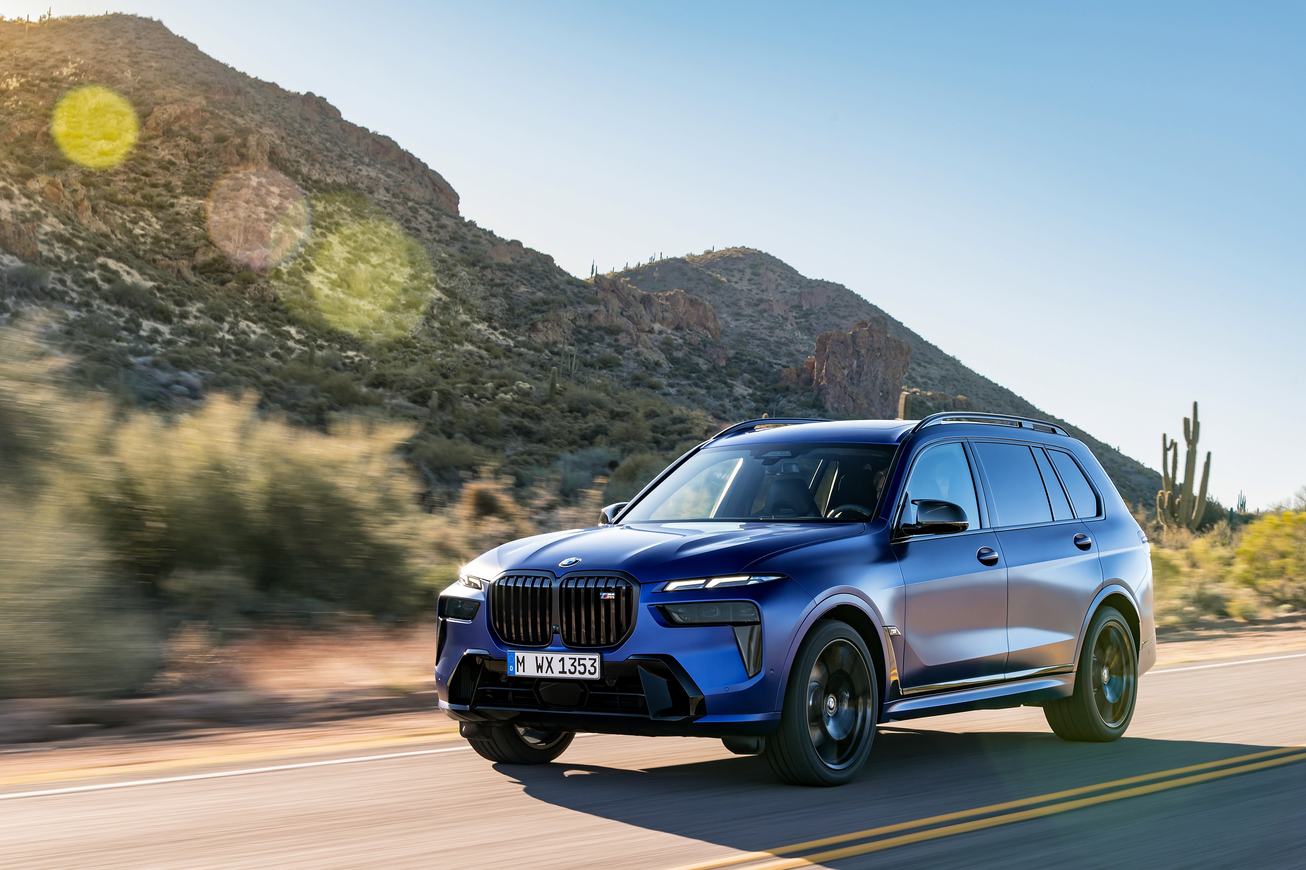 BMW X7 M60i xDrive driving on a desert road HD Wallpaper