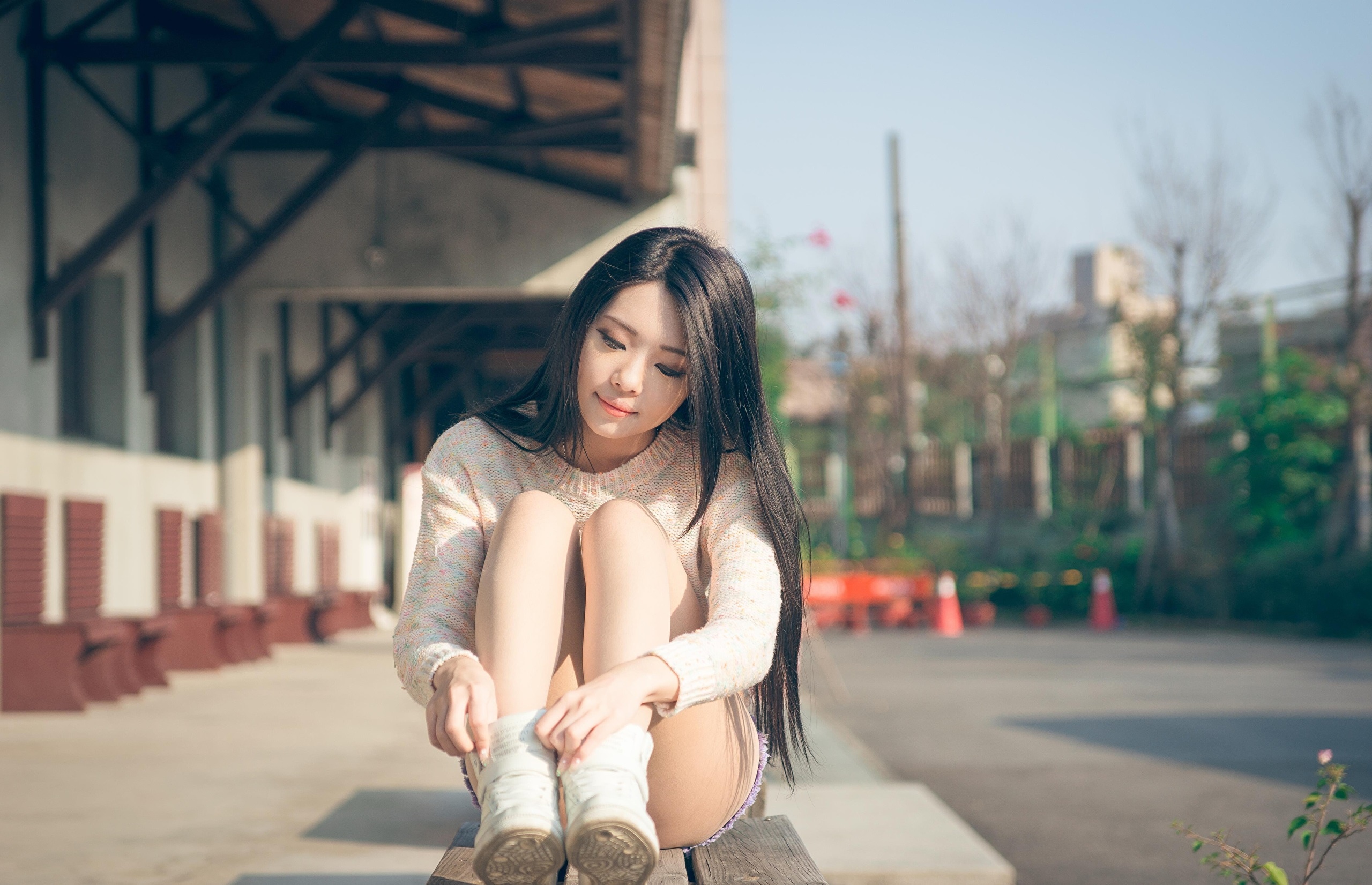 Asian woman in sweater sitting on bench HD Wallpaper